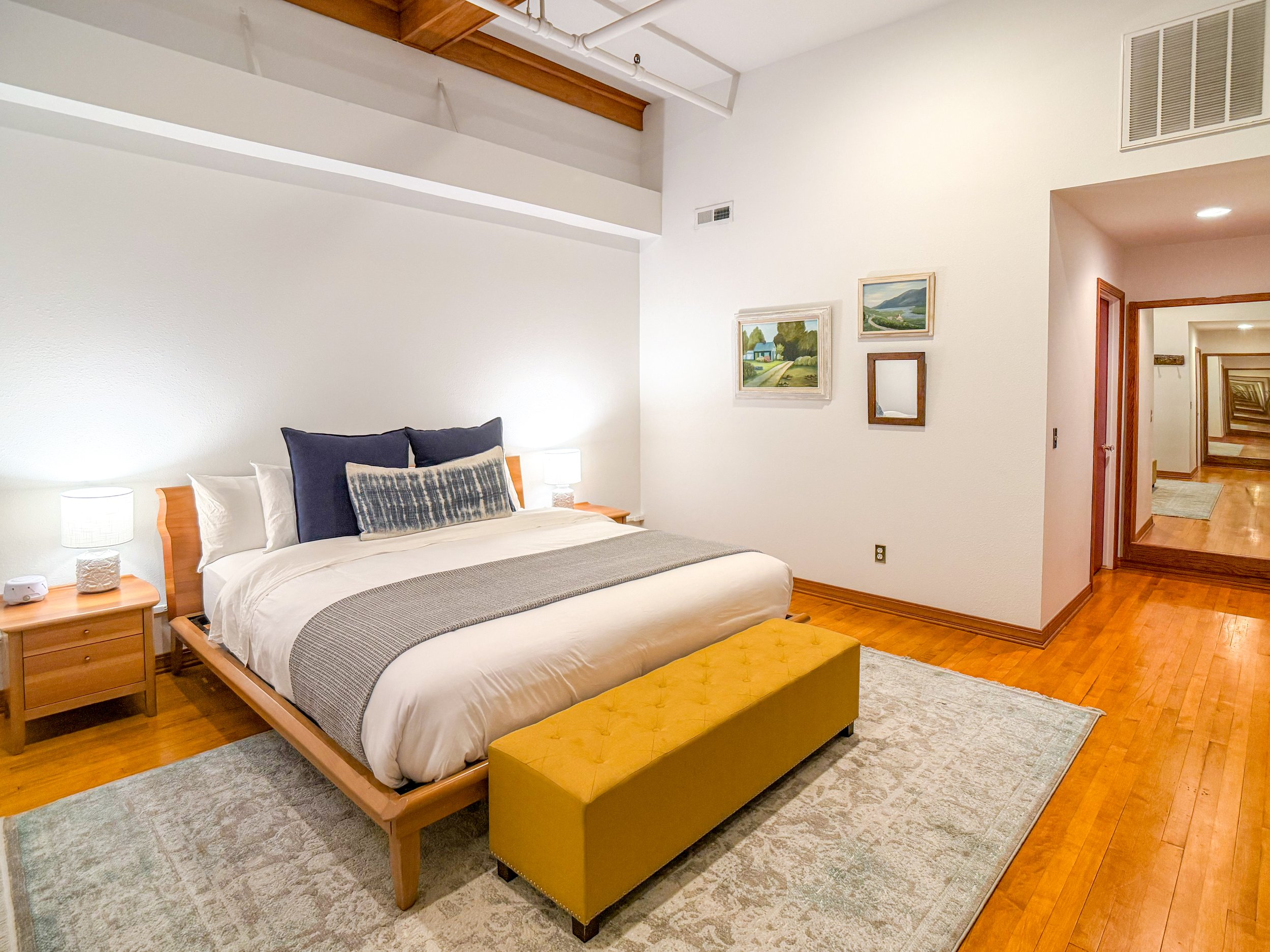 King bedroom with hardwood floors at Late Checkout WY vacation rental Sheridan Wyoming — warm finishes and quality linens