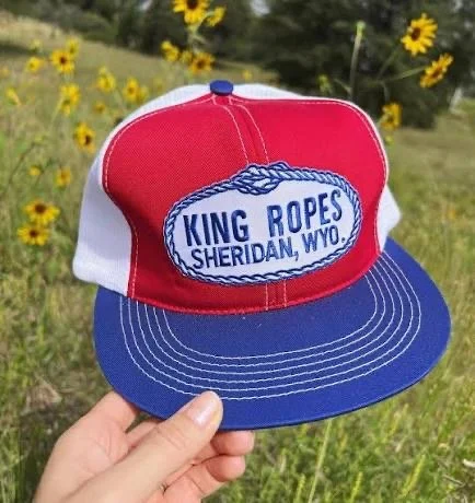 Tyler holding a red white and blue King Ropes Sheridan hat