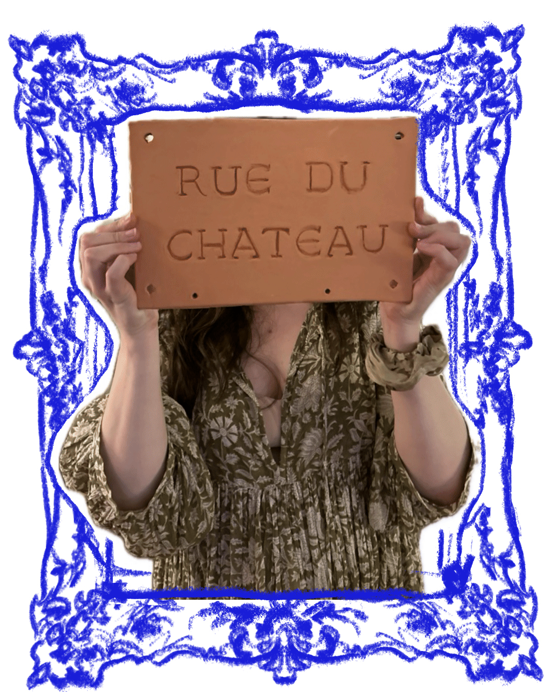Person holding a sign with the words "RUE DU CHATEAU" in front of their face, framed by a blue decorative border, wearing a patterned blouse and a scrunchie on their wrist.