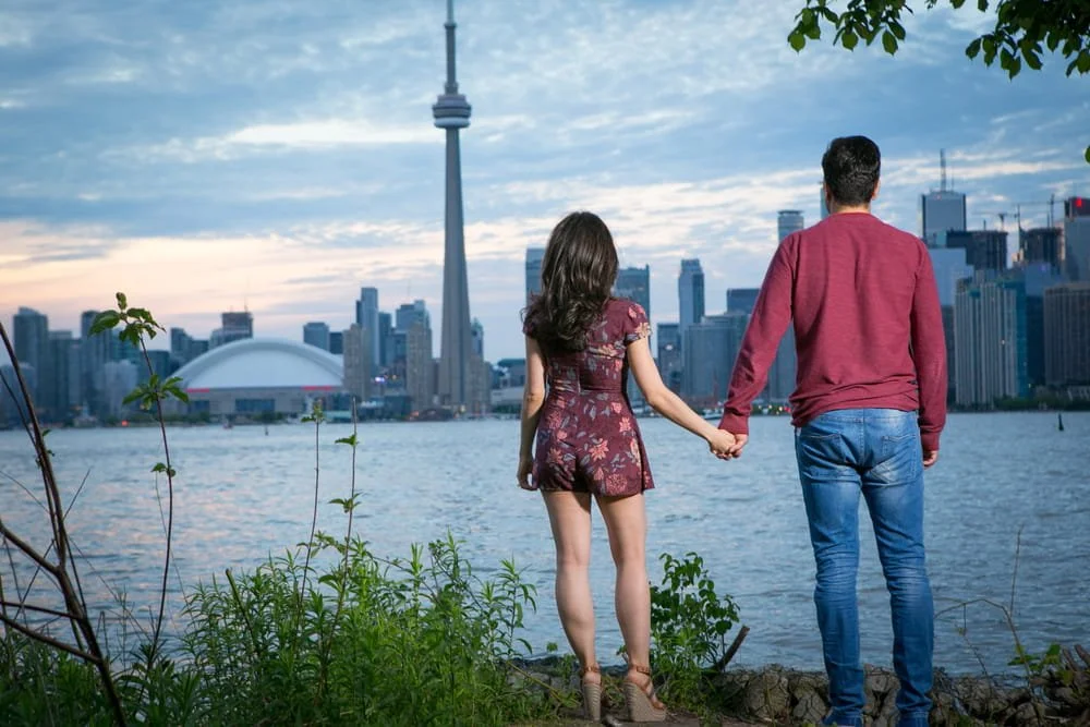 A couple holding hands by the water in Toronto