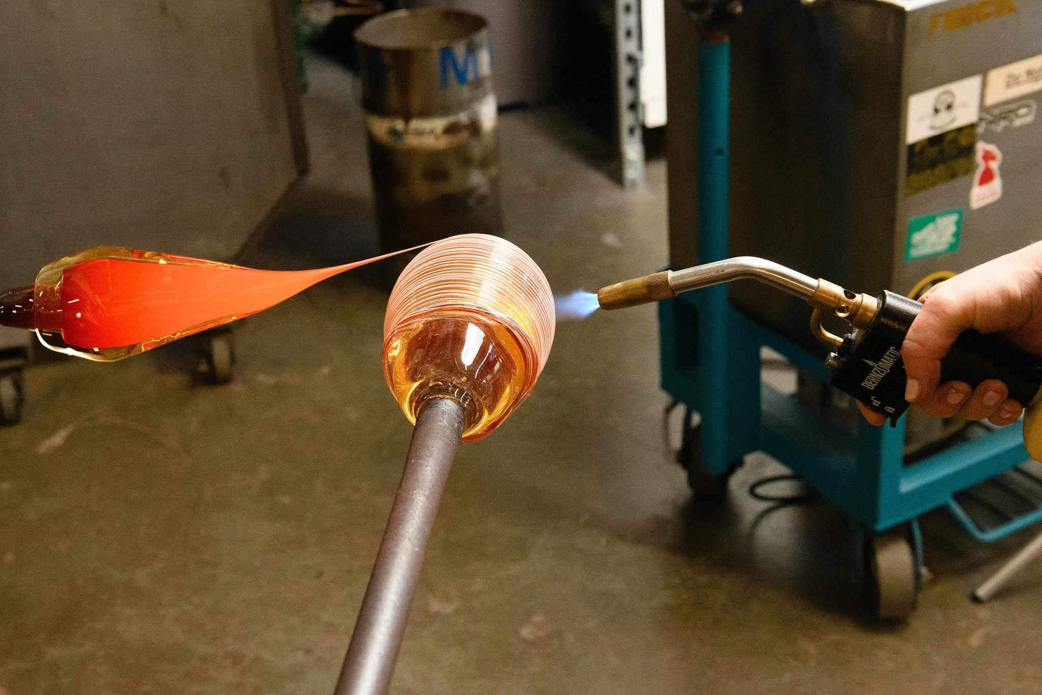 Glass trail being added to a glass bubble with a hot torch on the opposite side