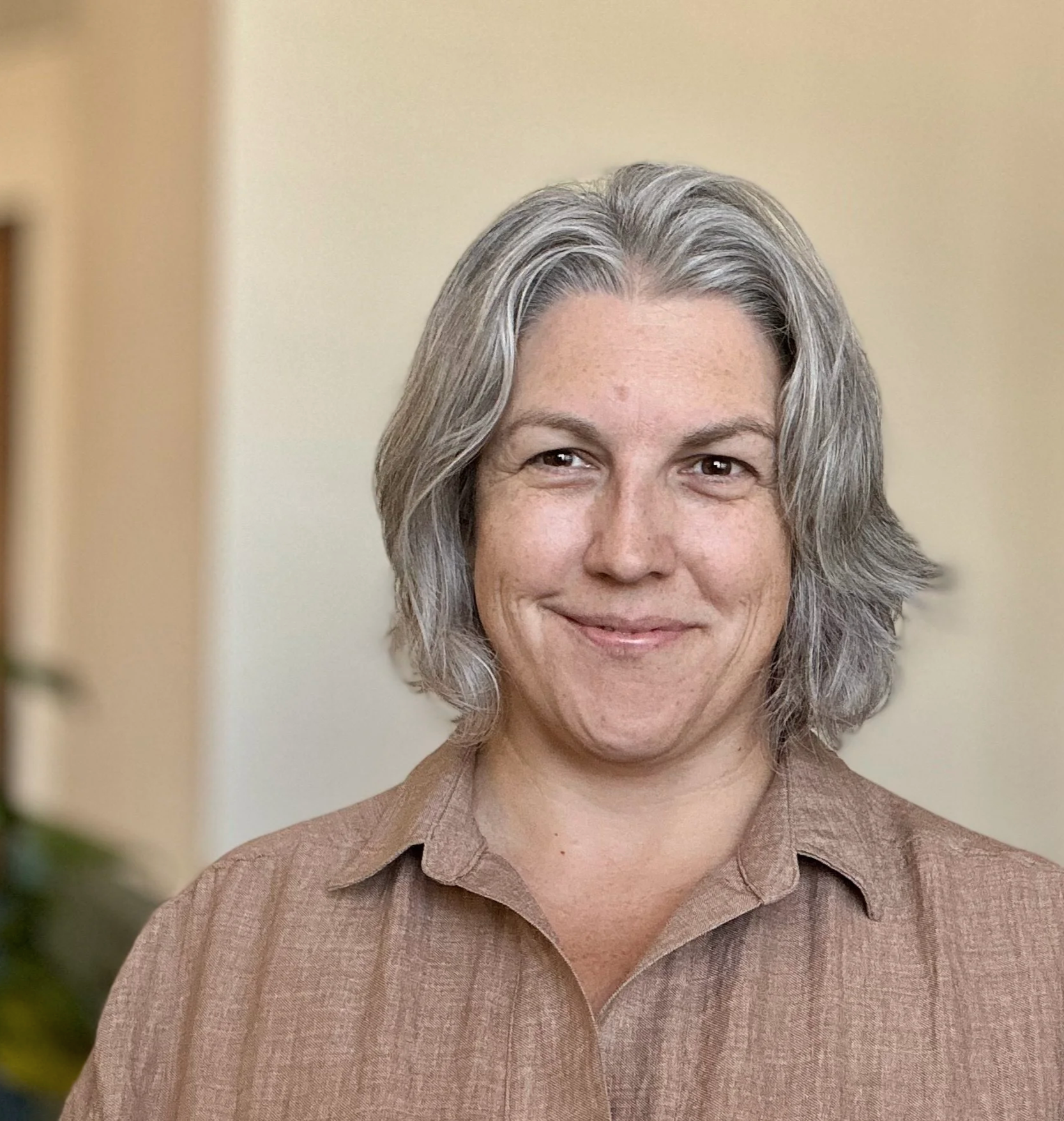 Amanda Gormley, LAC, standing indoors against a beige background.