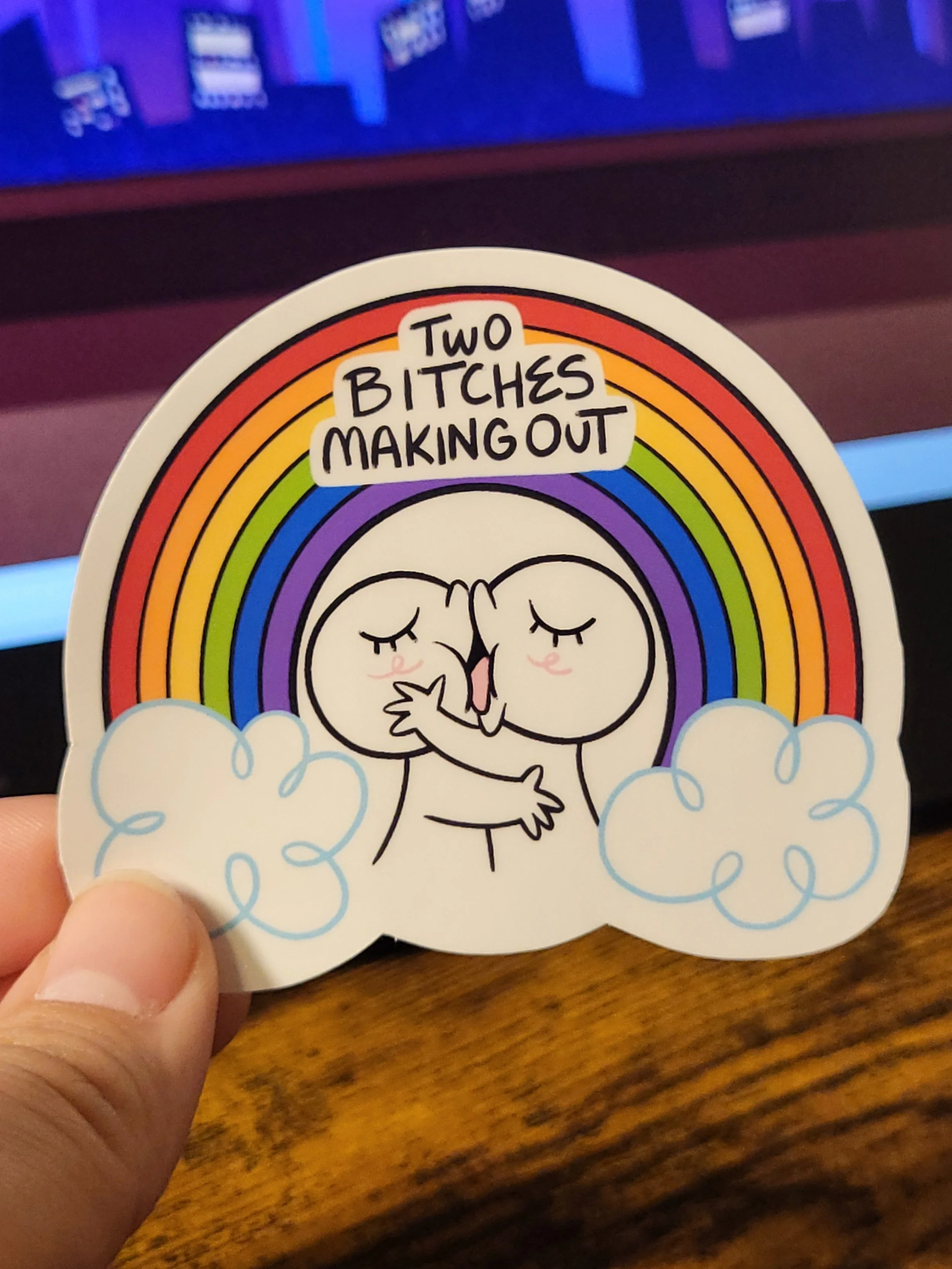 two figures kissing under a rainbow with text "two bitches making out"