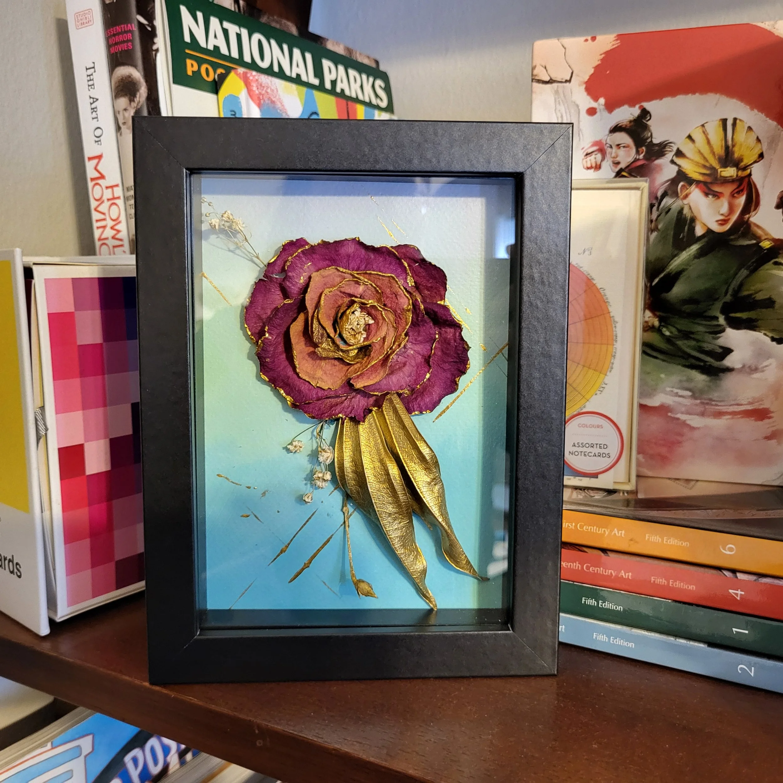 framed acrylic flower painting on shelf