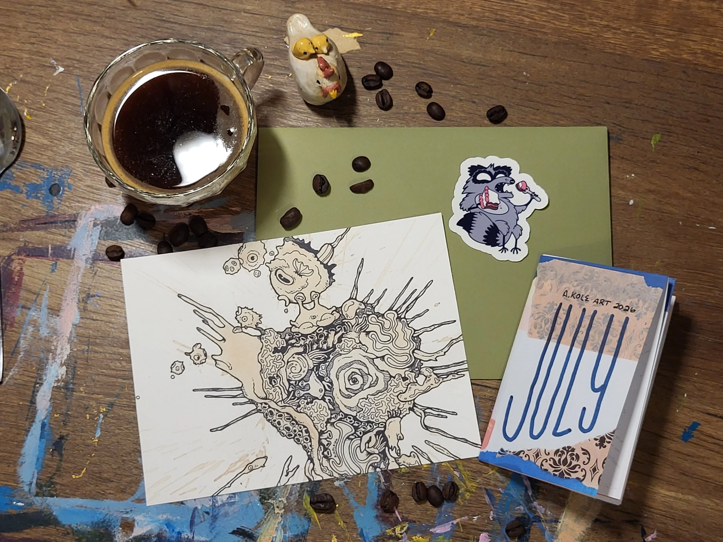 an art print, raccoon sticker, coffee zine