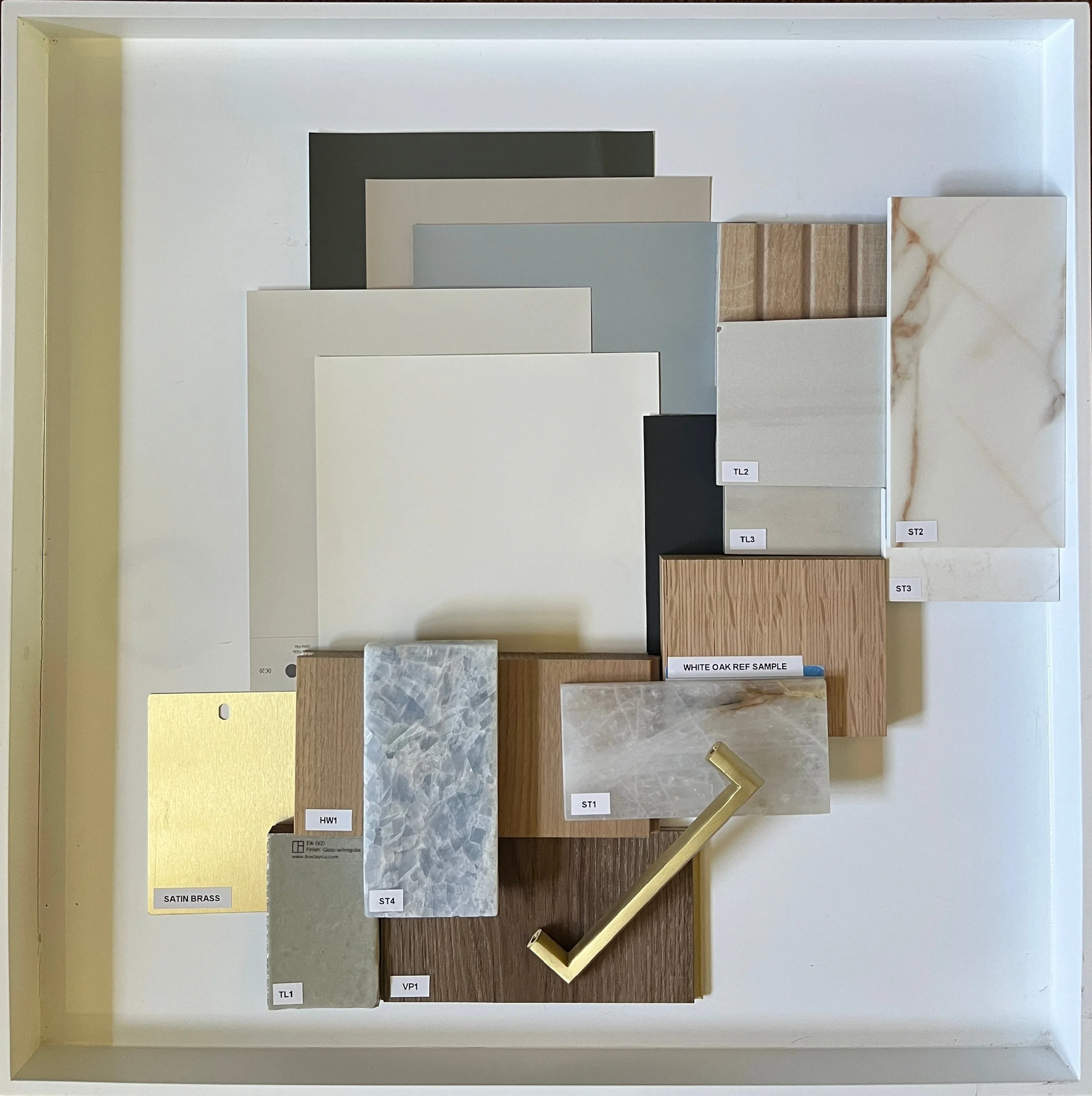 Display of various sample materials and colors including white, gray, wood finishes, marble, and metal, arranged for selection.
