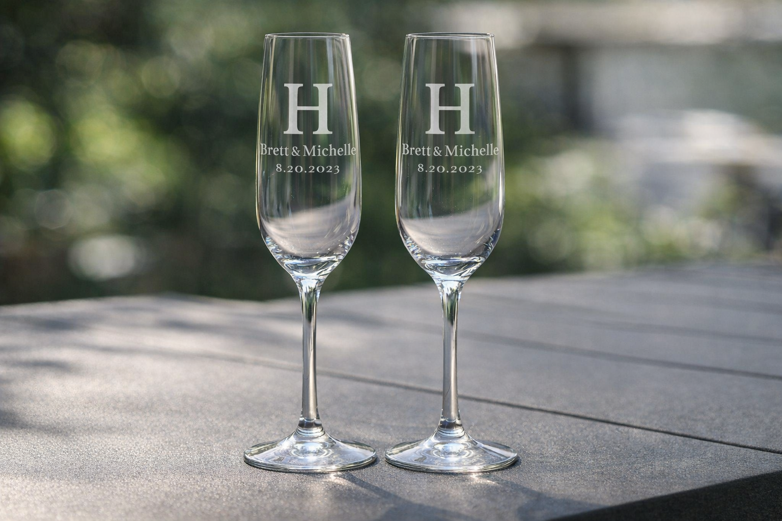 Personalized monogram champagne flutes with initial H, names Brett and Michelle, and wedding date engraving