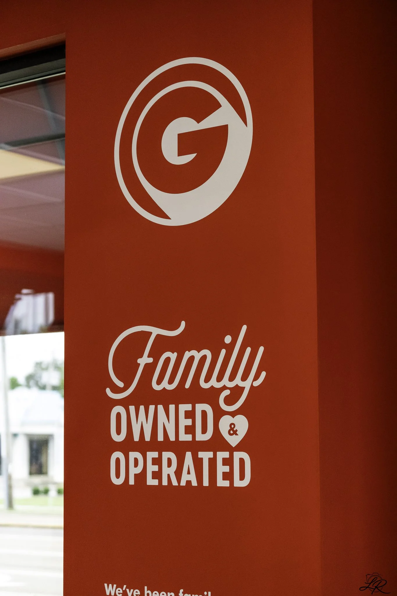 Red background sign indicating the business is family owned, operated, and managed.