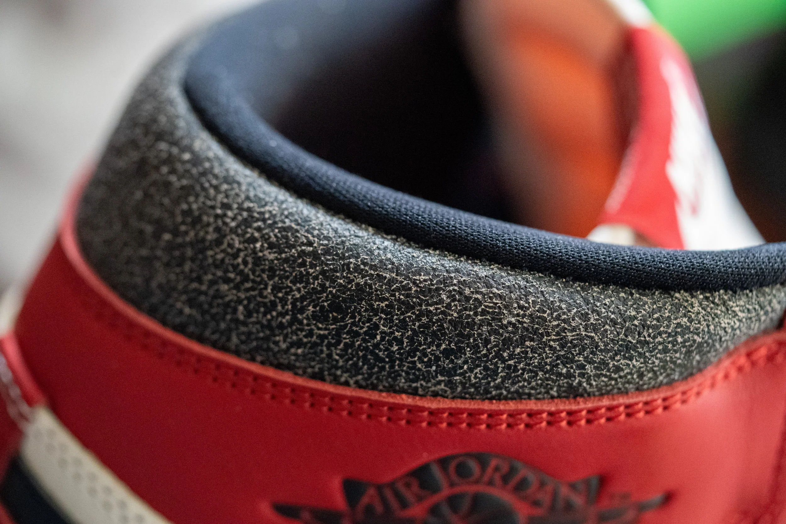 Close-up of the tongue area of a red and black Air Jordan sneaker, showing the textured inner lining and stitching.