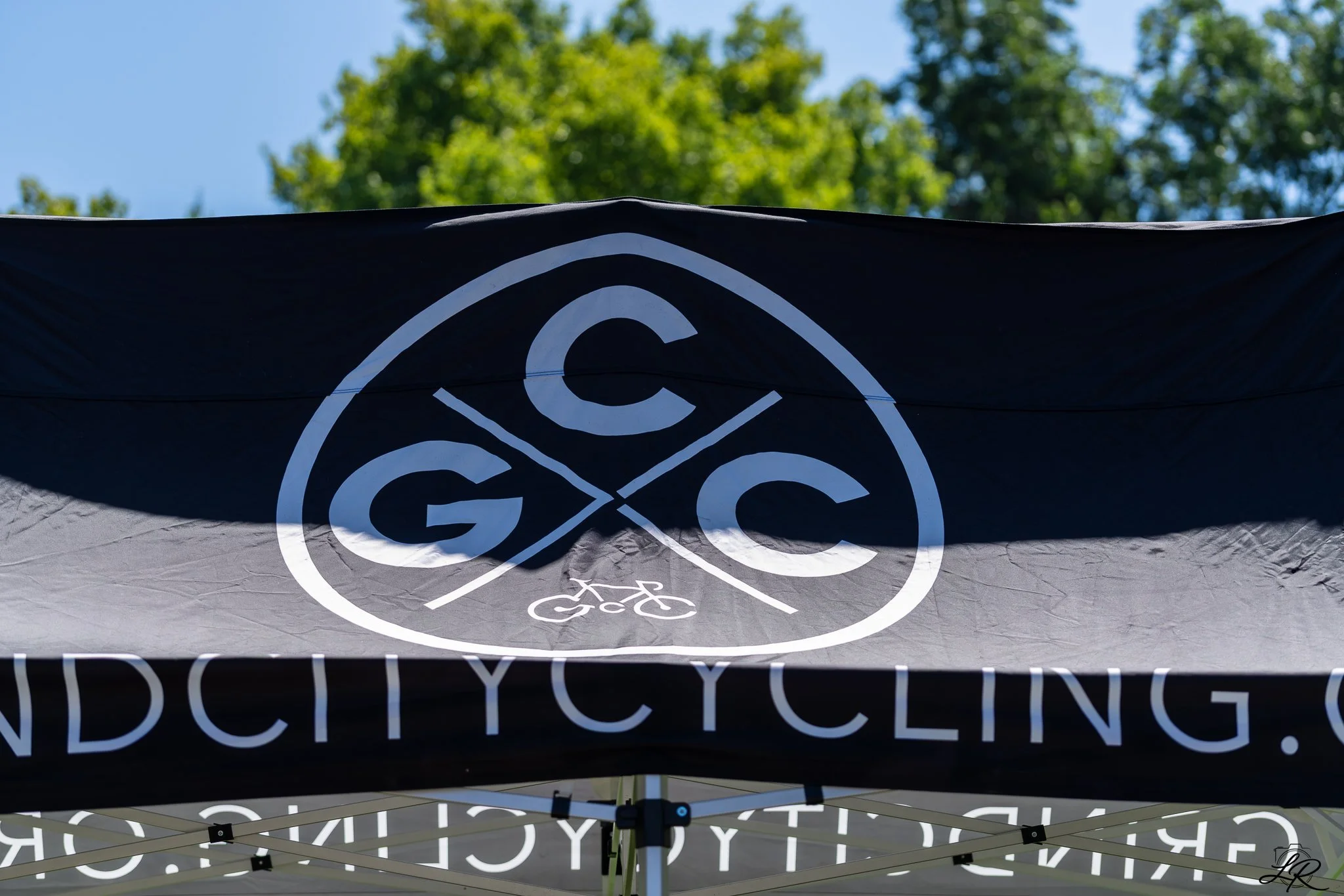 A black tent with white text and symbols related to cycling, including a bicycle icon and the word 'CYCLING'.