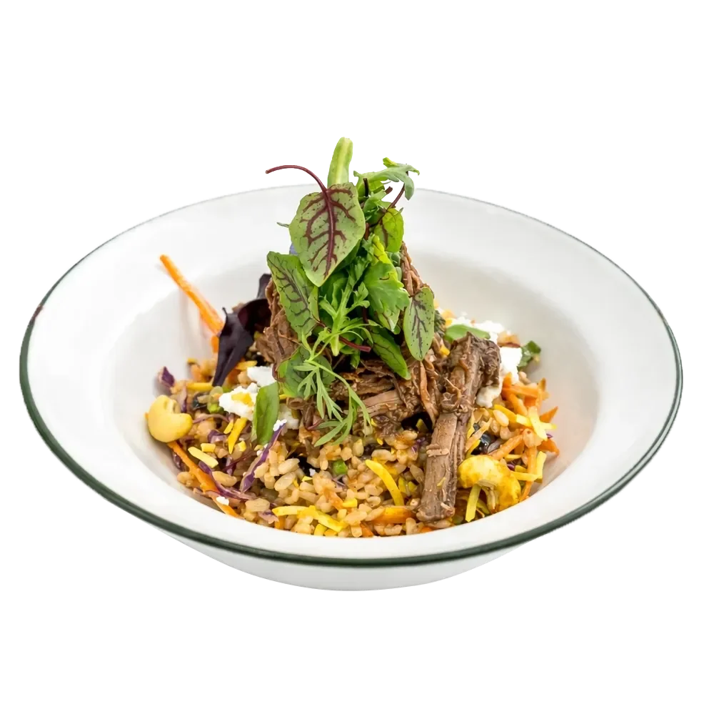 A bowl of rice with shredded carrots, corn, purple cabbage, topped with shredded beef and fresh greens.