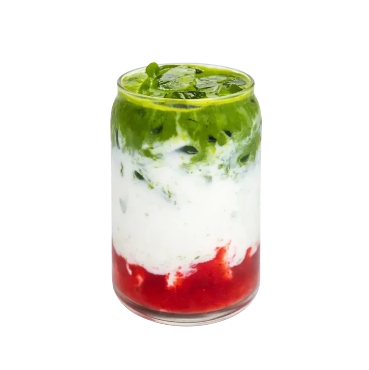 A layered drink in a clear glass with green, white, and red layers, topped with ice and fresh mint leaves.