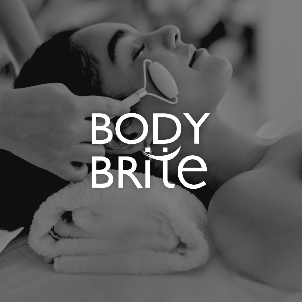 Person receiving a facial or skincare treatment with a device on their face, lying on a towel with closed eyes.