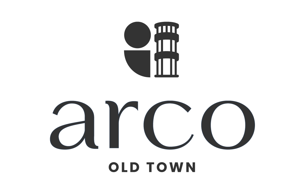 Logo for Arco Old Town featuring a stylized tower and circular design element.