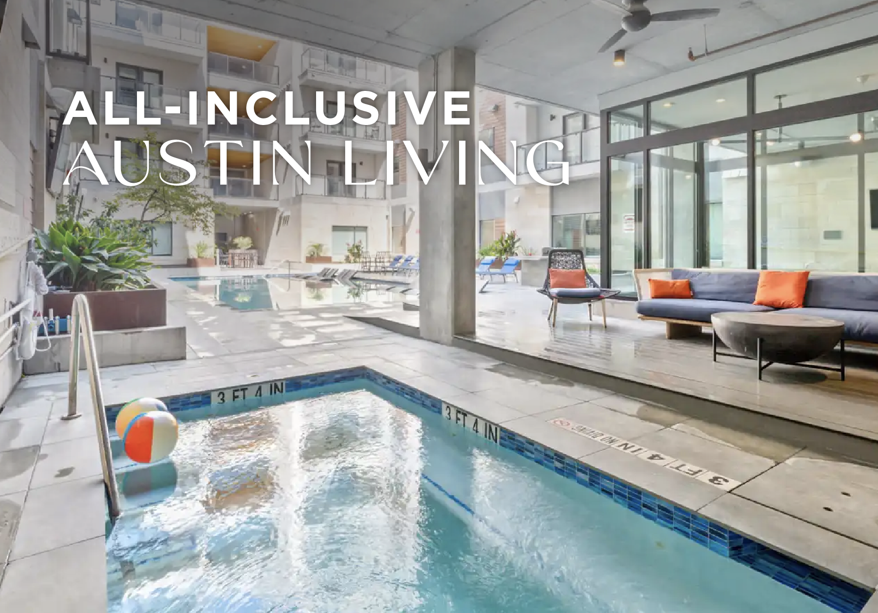 Indoor pool area with lounge chairs and a small pool with a beach ball, surrounded by glass walls and outdoor pool with seating, in an apartment building.