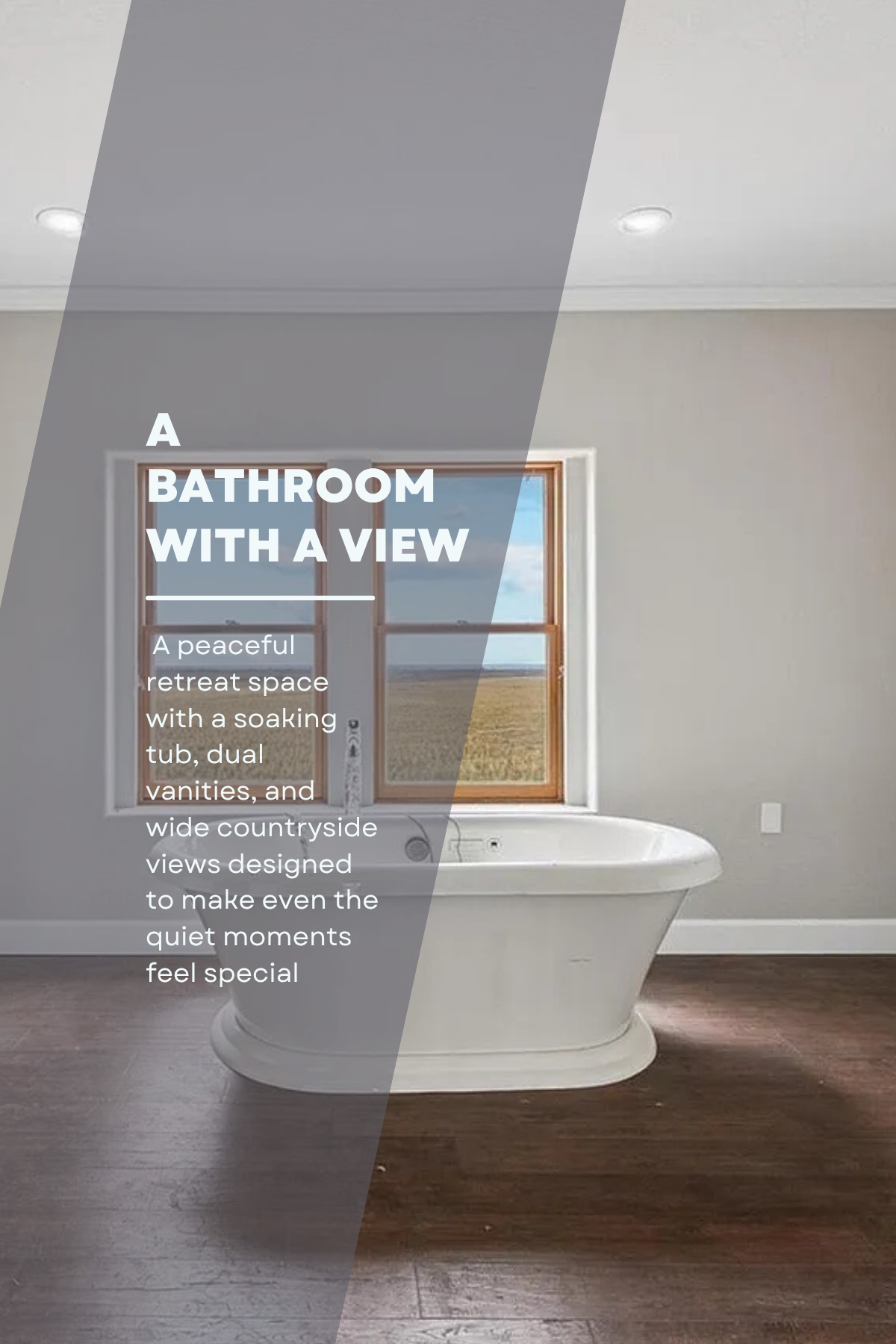 A bathroom with a view of an open window showing a countryside landscape with grassy fields and a blue sky. There's a white soaking tub, and the room has light-colored walls, dark wooden flooring, and recessed ceiling lights.