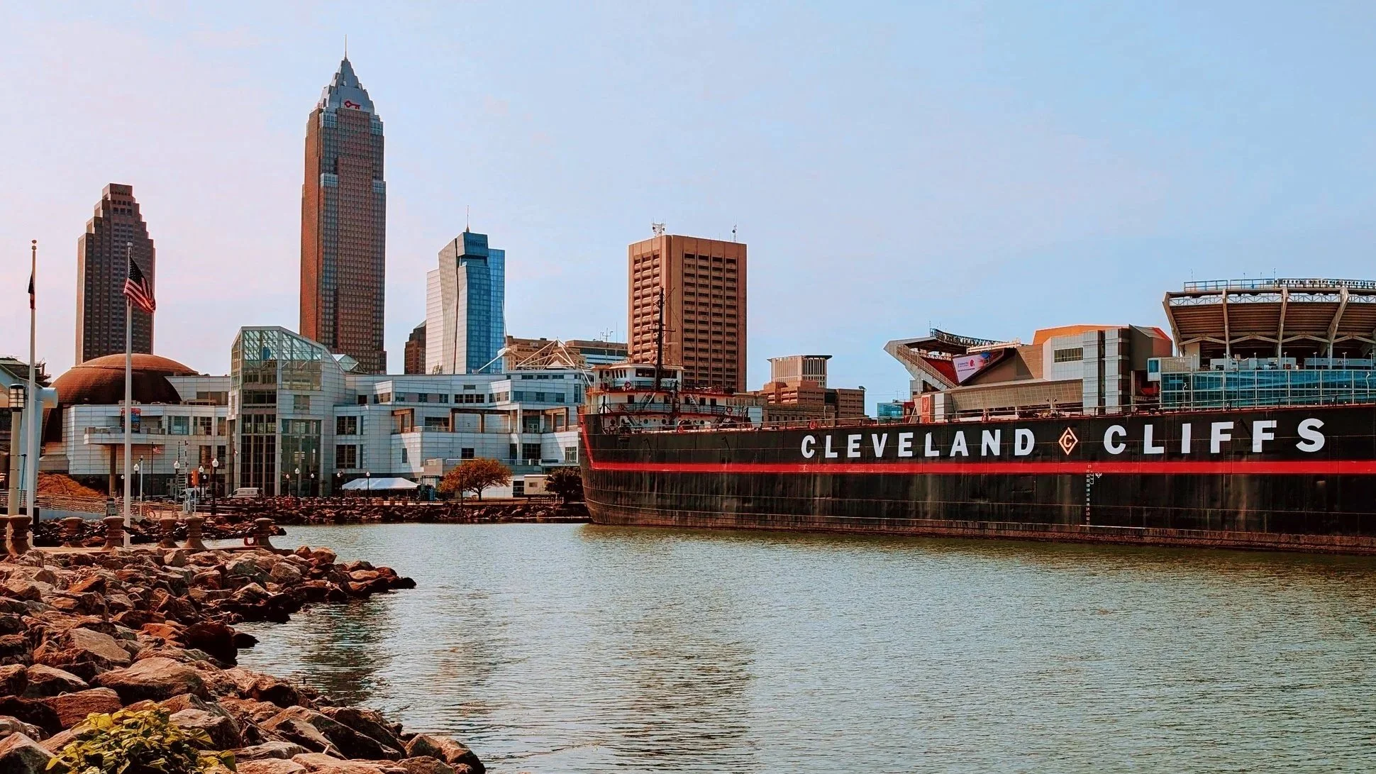 View of Cleveland, Ohio skyline with buildings and the USS Cleveland ship docked on the waterfront
