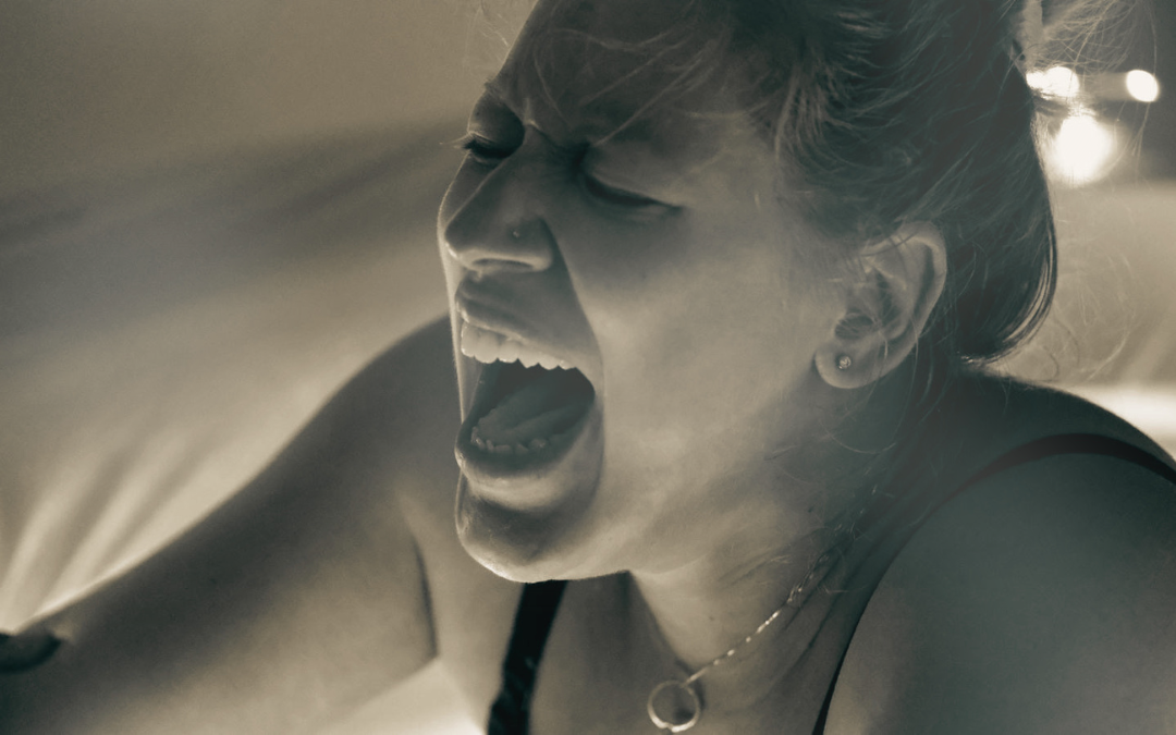 A woman with her mouth open, appearing to be yelling or crying.