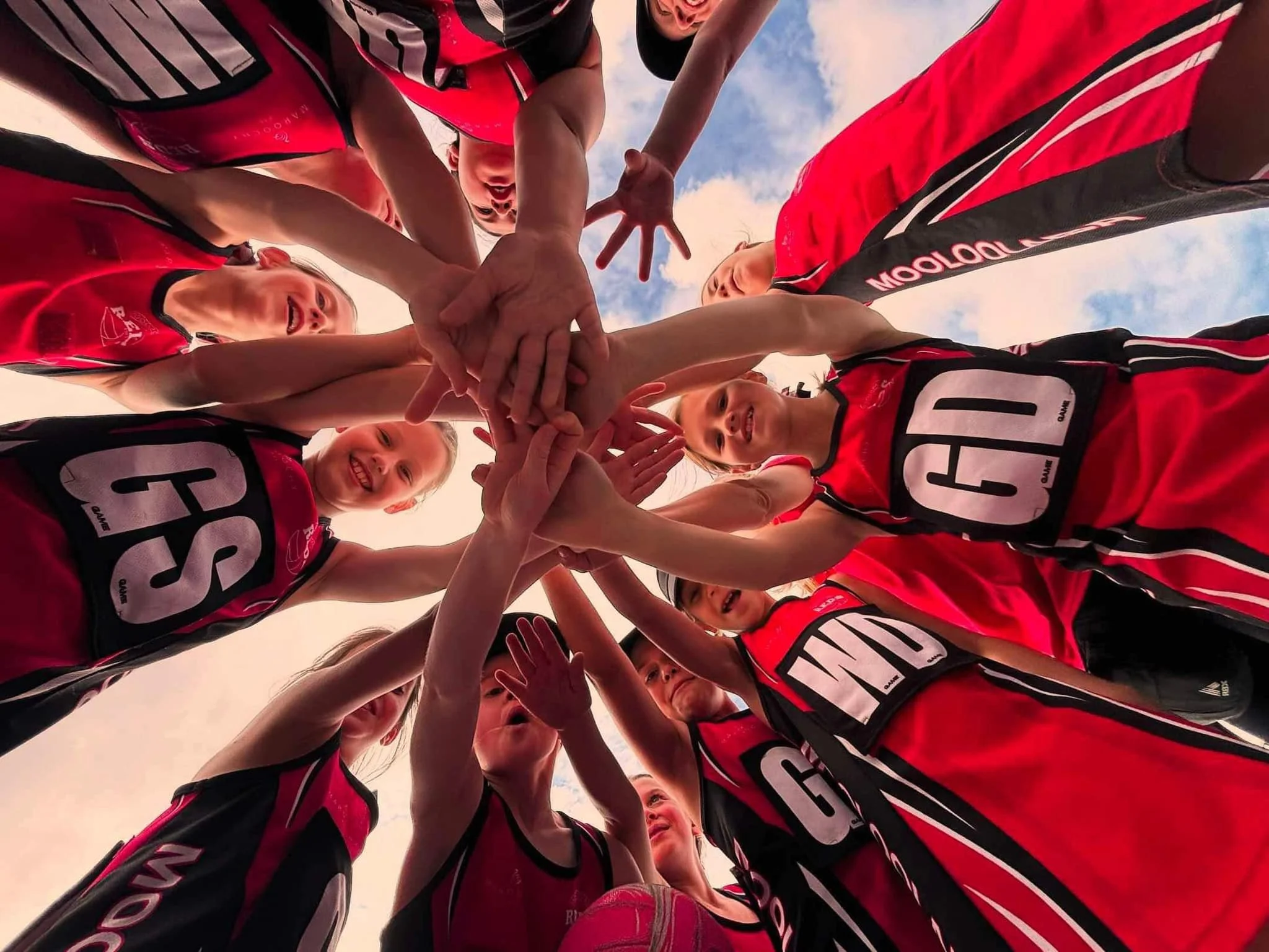 Mooloolaba Reds team with their hands in a circle.