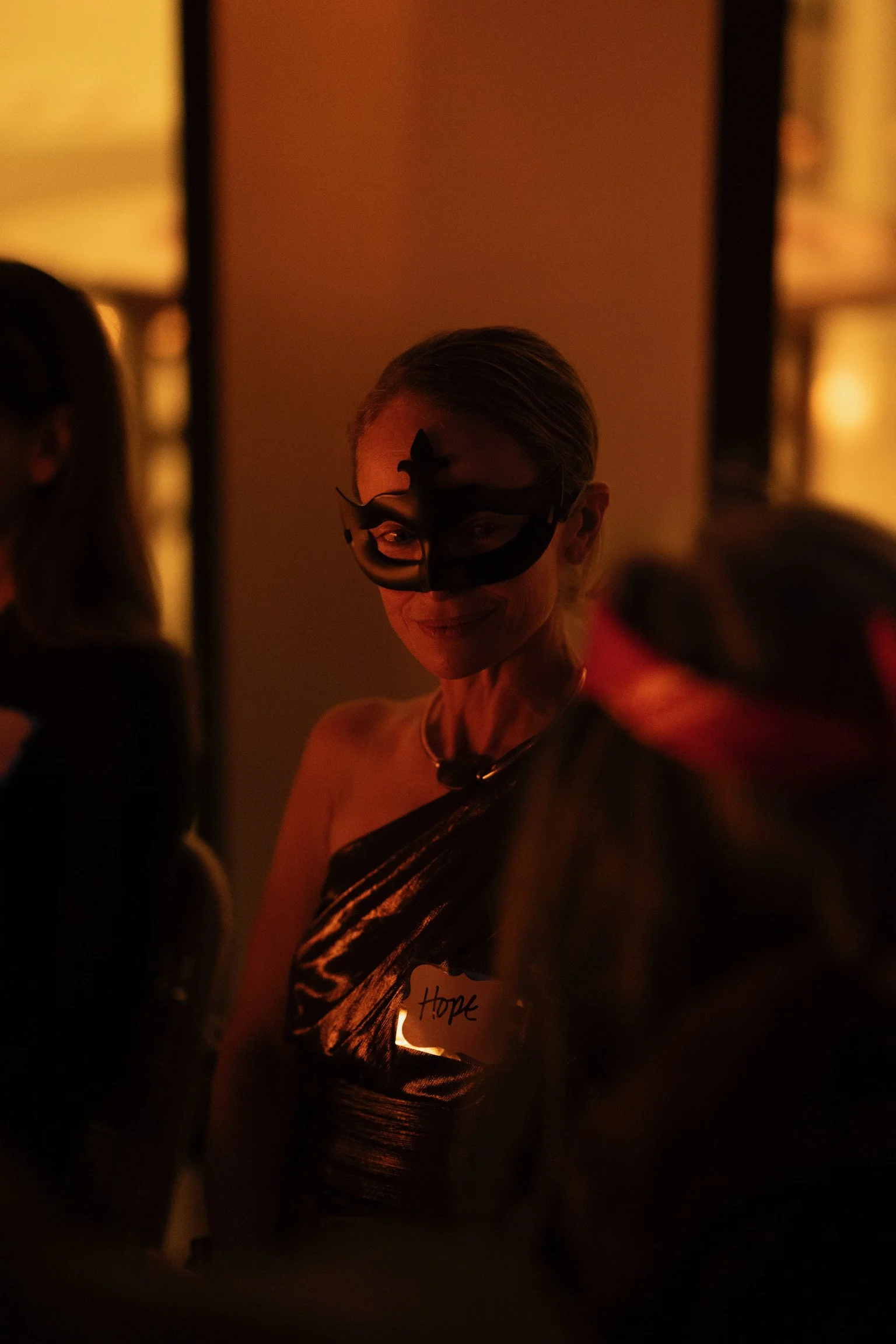 A Curtain Call guest embraces a hidden identity during an immersive social strategy experience, where storytelling, mystery, and human connection shape the outcome.