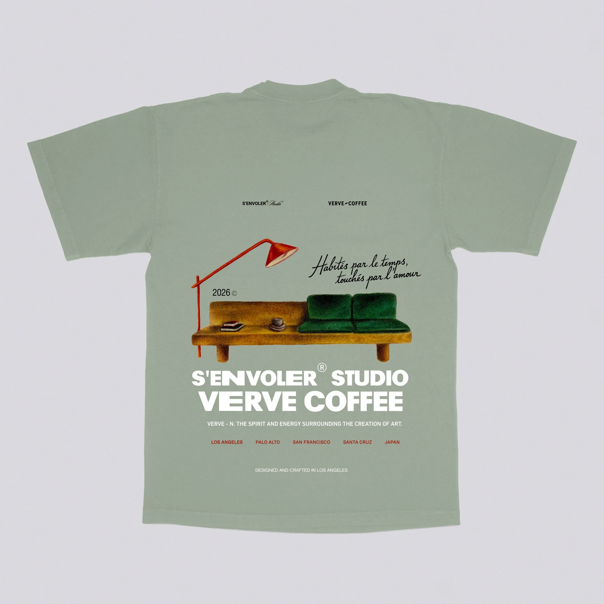 Green T-shirt with a design featuring a wooden sofa, green cushions, a red desk lamp, and French text, along with brand and location information.
