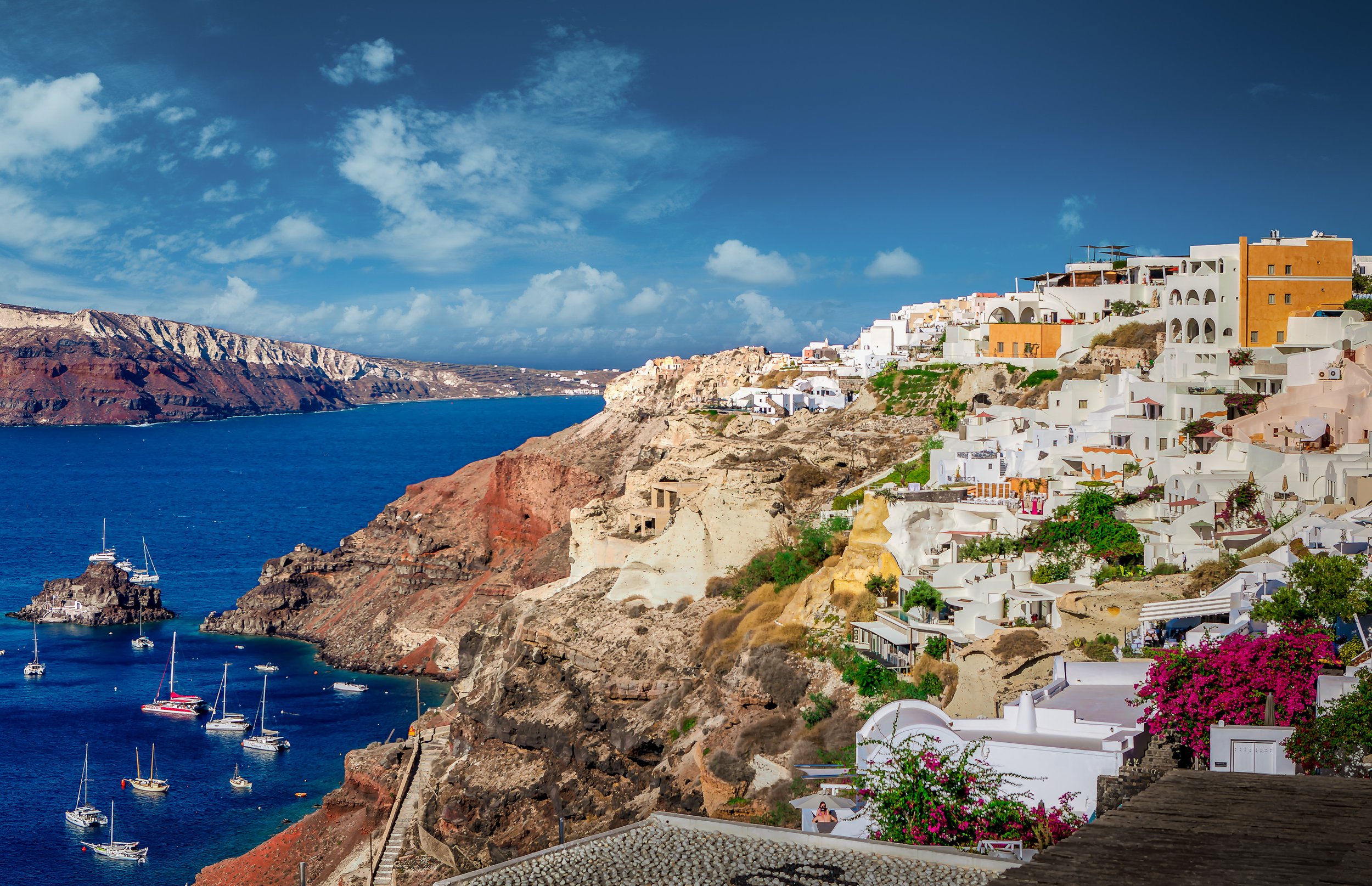 Oia village on Santorini caldera with boats, Greece