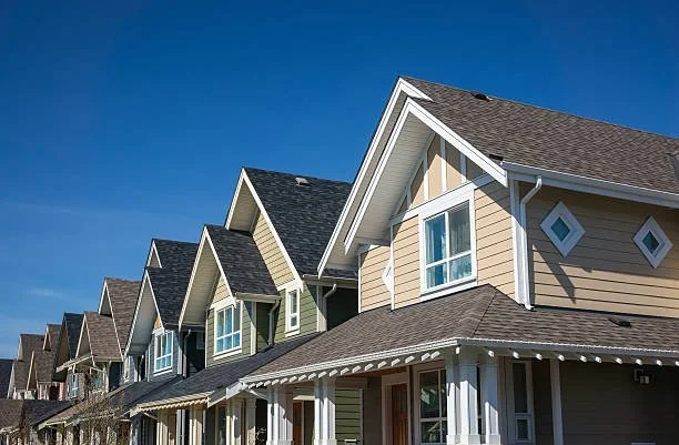 Row of houses with gabled roofs under a clear blue sky.