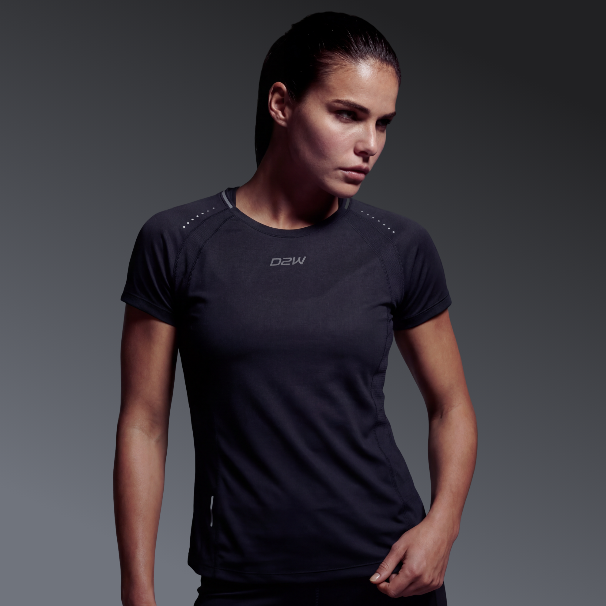 A woman in black athletic wear posing against a neutral background.