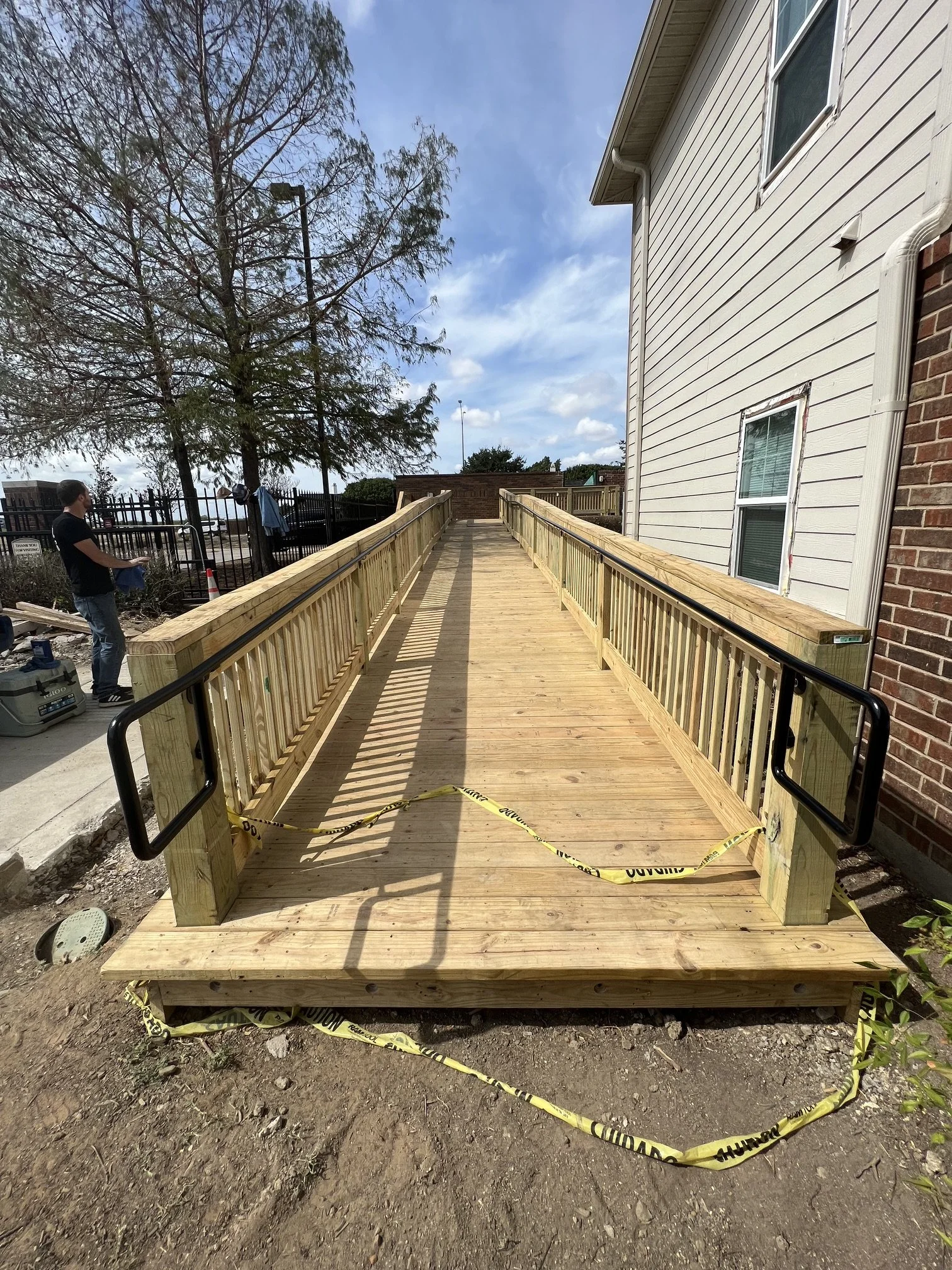 ADA-compliant metal handrails installed on a dumpster ramp at a Dallas-Fort Worth (DFW) apartment complex, improving safety and accessibility for residents and maintenance staff. Custom-fabricated steel railings designed to meet ADA standards, provid