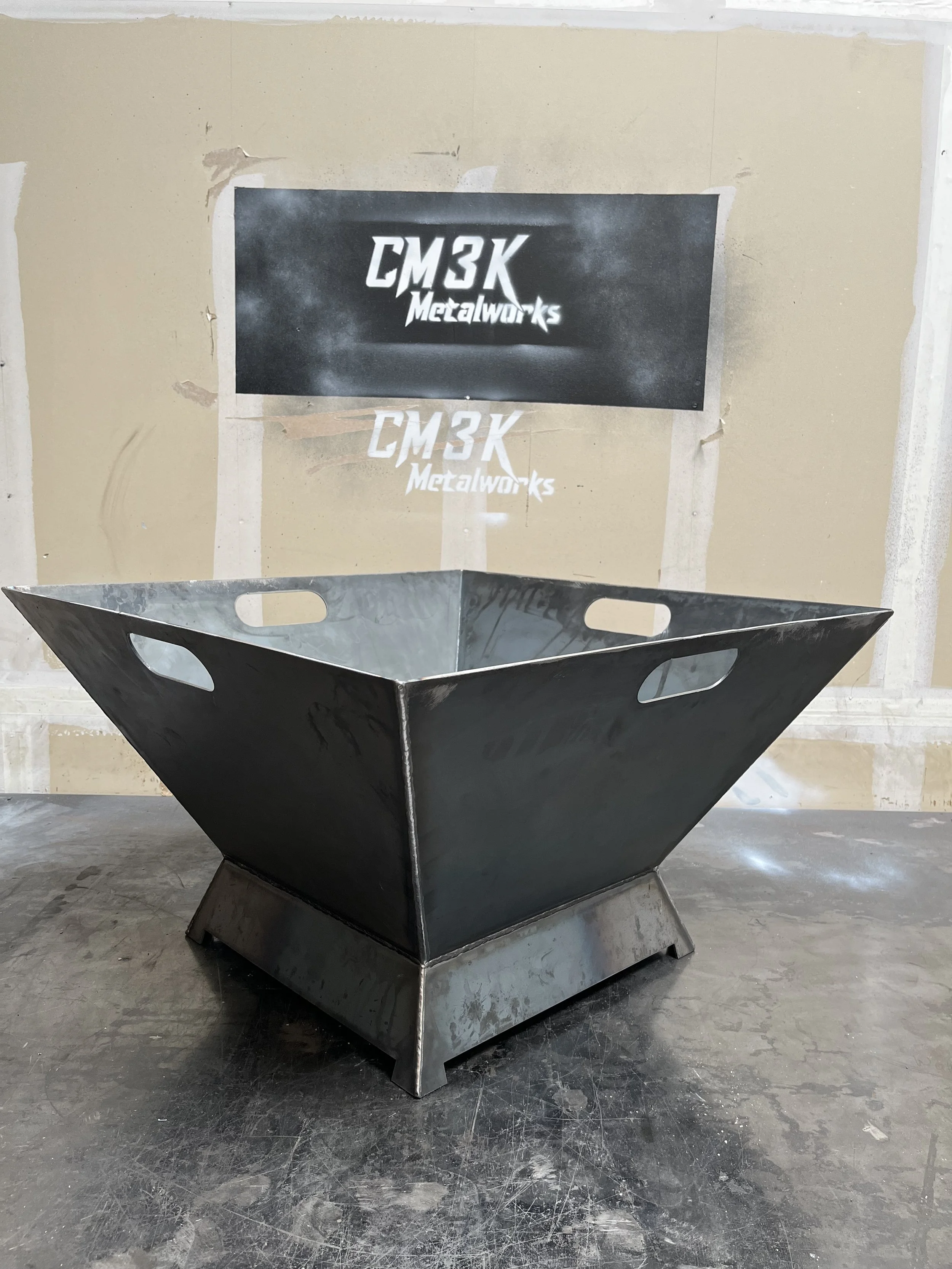 Custom CNC-cut steel fire pit handcrafted in the Dallas–Fort Worth (DFW) area by CM3K Metalworks. This high-end, modern fire pit features precision-cut handles, clean welds, and a sleek geometric design, perfect for luxury outdoor living spaces. Buil