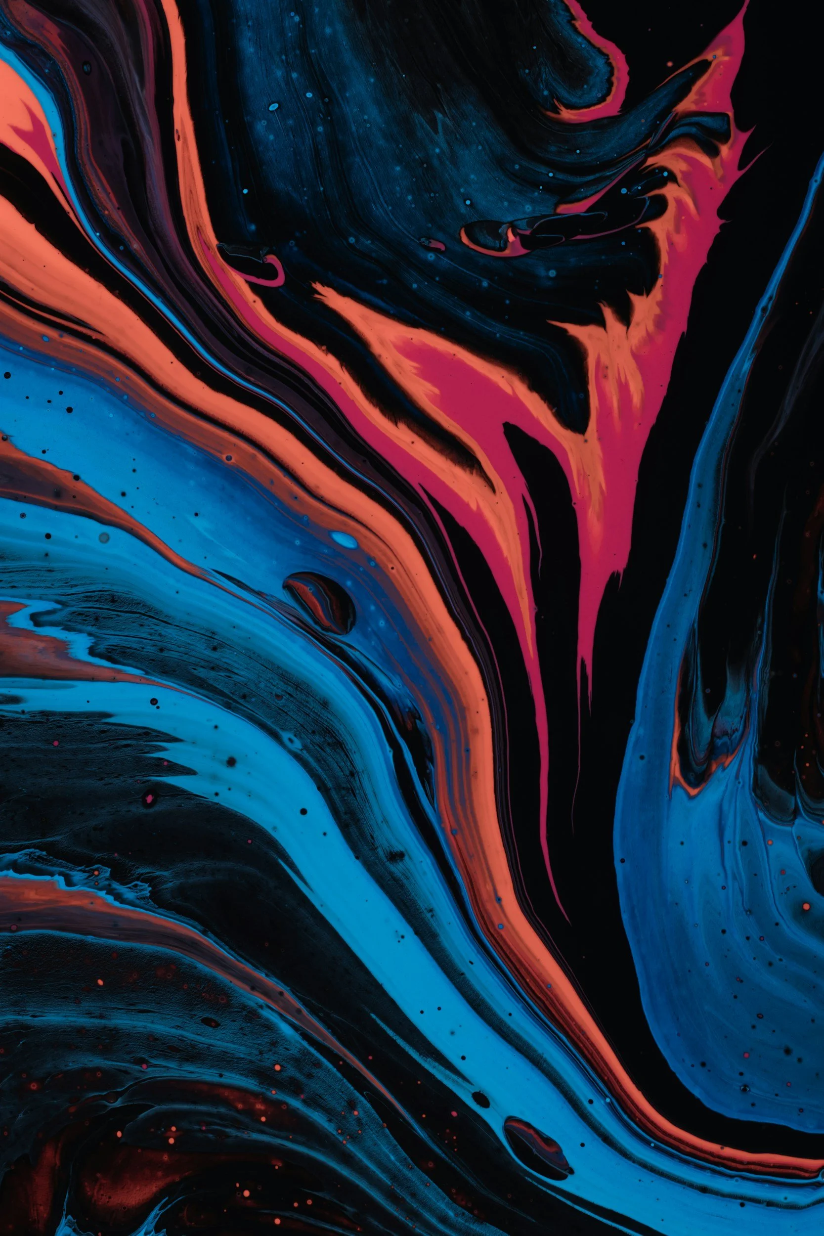 Abstract swirl of black, blue, and red-orange colors creating a fluid, marbled pattern.
