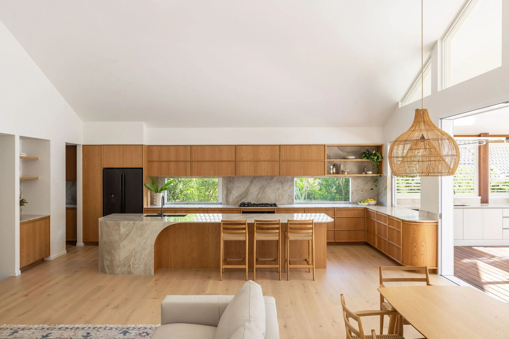 American Oak Timber Veneer Kitchen with Taj Mahal benchtop and splashback. Taj Mahal Island bench with curved end.