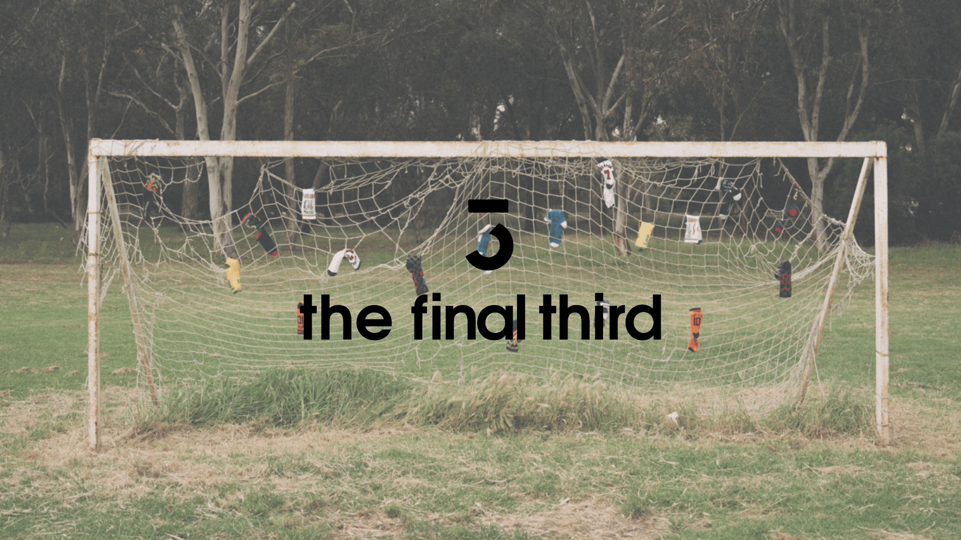 A soccer goal with a net decorated with colorful socks hanging from the netting, on a grassy field with trees in the background, overlaid with text '5 the final third'.
