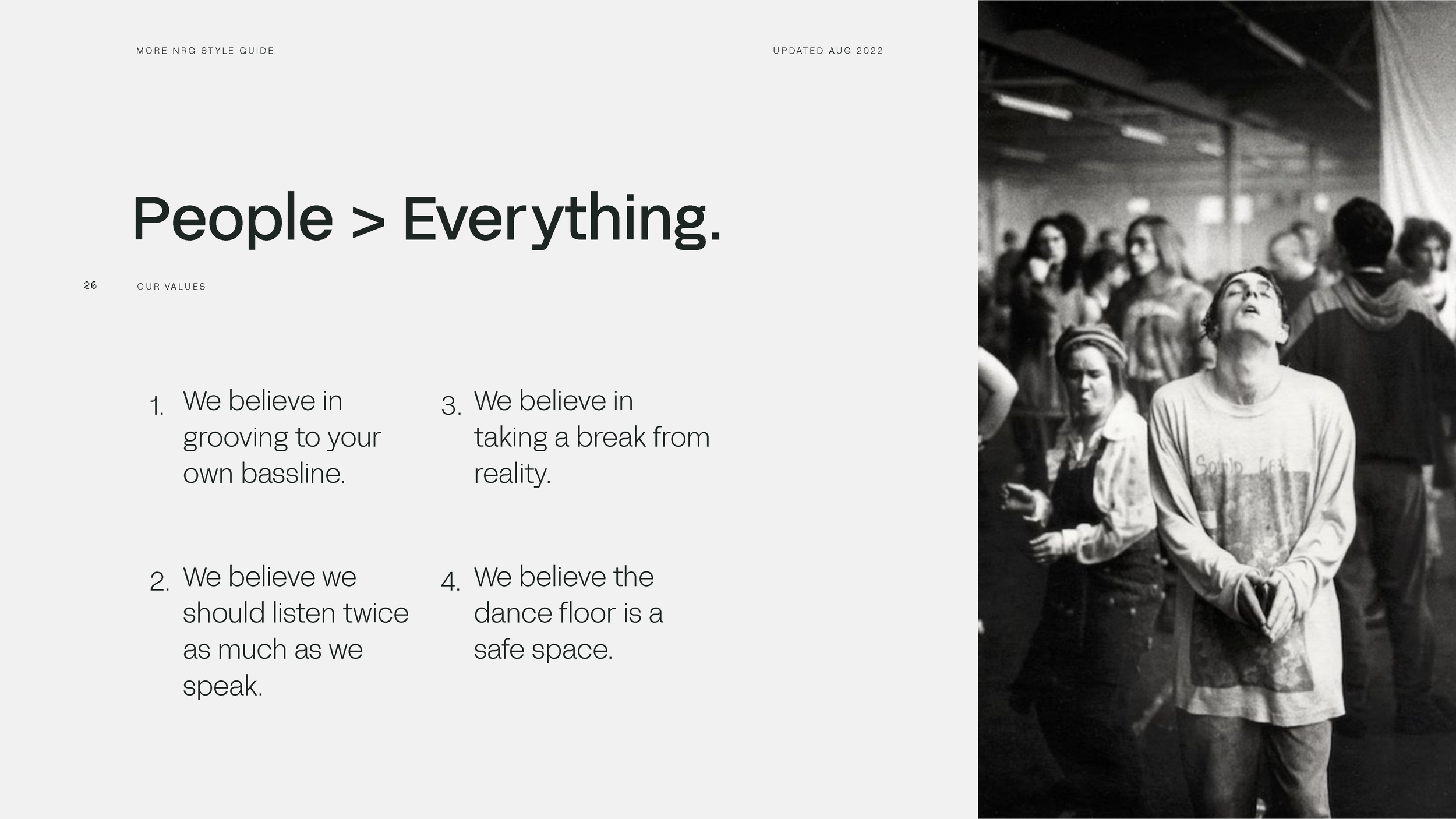 Black and white photo of a woman with her eyes closed and head tilted back, standing among a crowd in an indoor space.