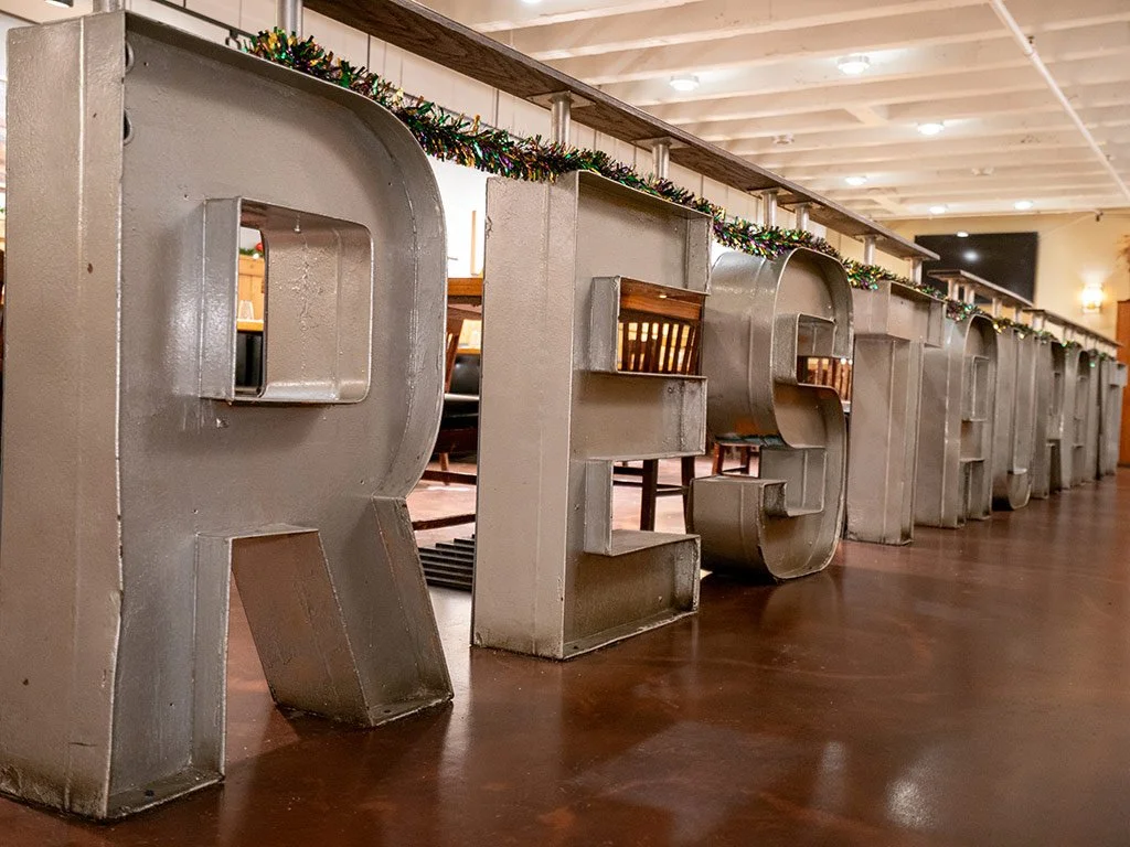 Prairie Moon's decorative 'RESTAURANT' is displayed indoors, decorated with holiday garlands along the top.