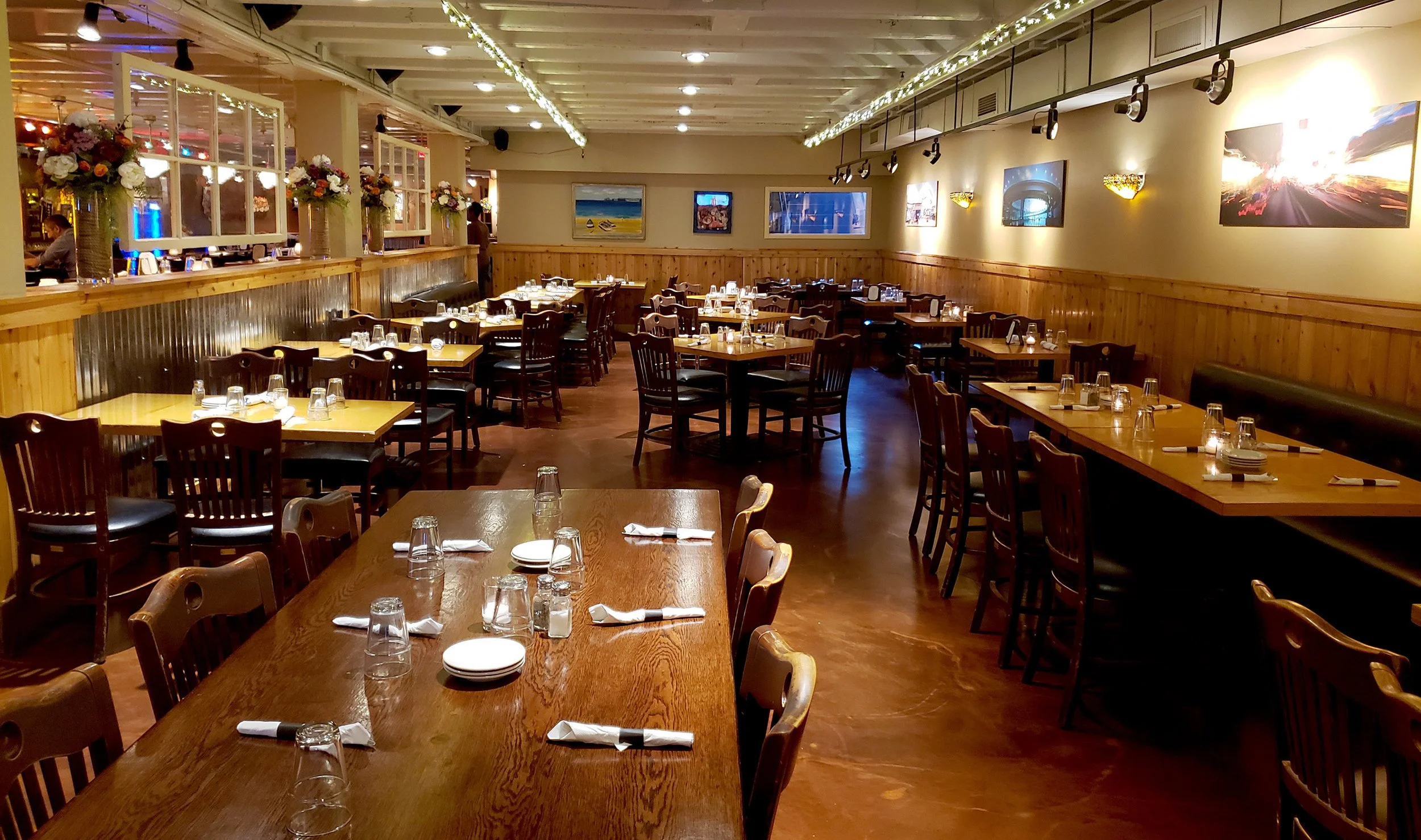 Evanston restaurant, Prairie Moon, is a cozy and inviting location with wooden tables and chairs, dim lighting, artwork on the walls.