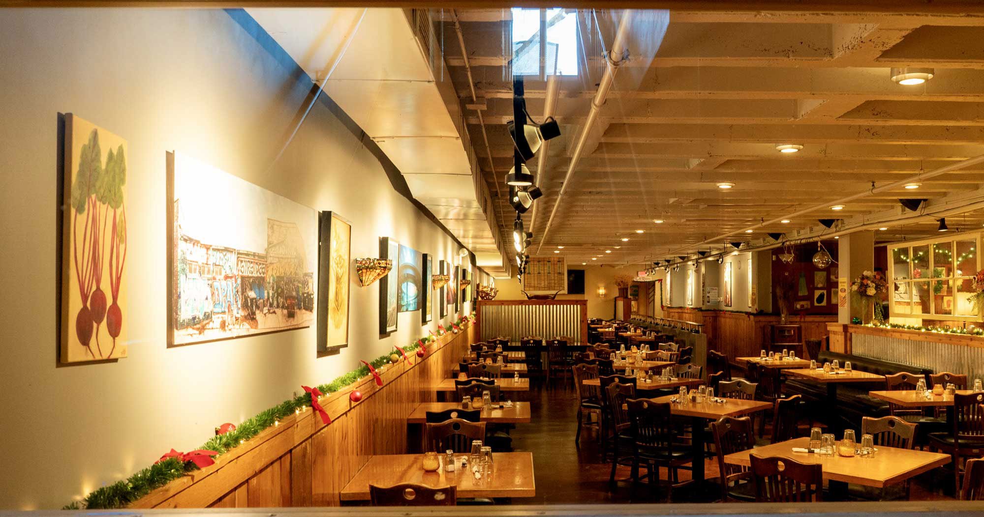 Inside Prairie Moon's warmly lit restaurant in Evanston, with decorated tables and artwork on the walls.