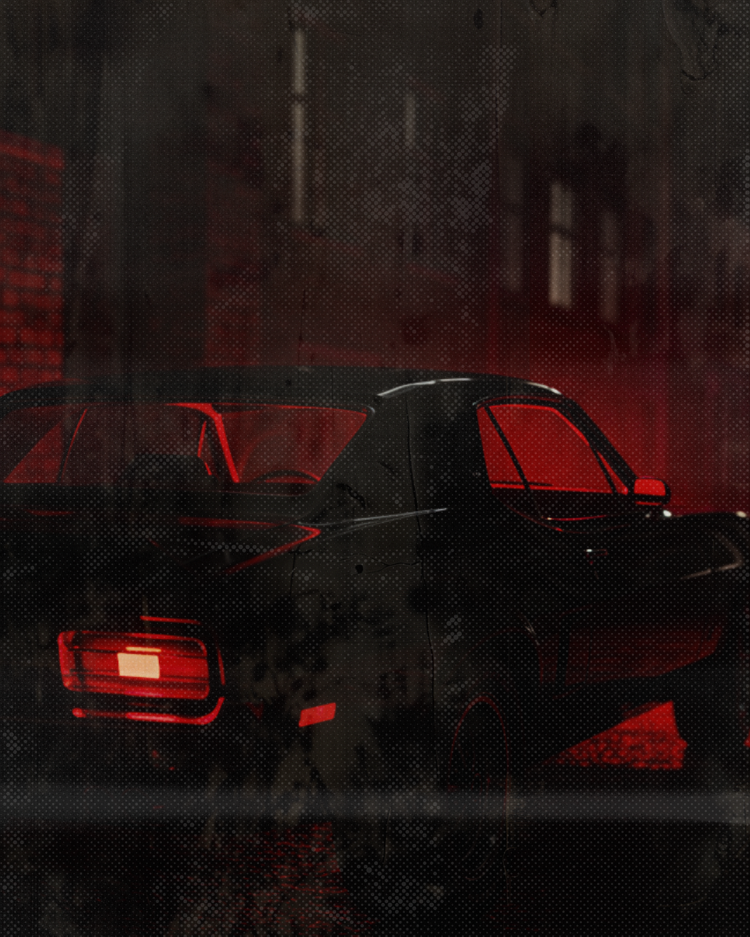 A dark sports car with illuminated red interior and taillights, parked on a wet city street at night with buildings in the background.