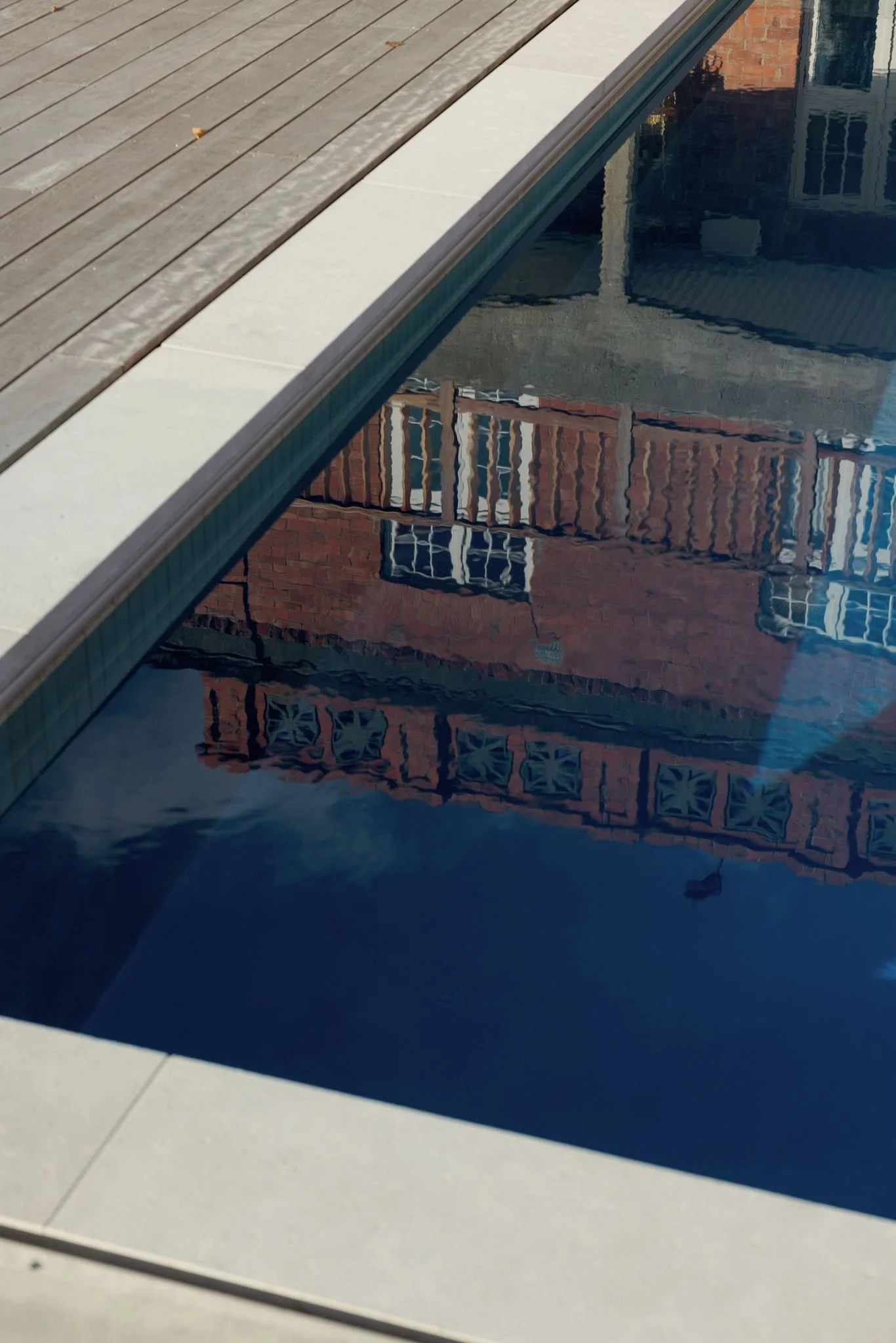 Reflection of brick building with windows in swimming pool water