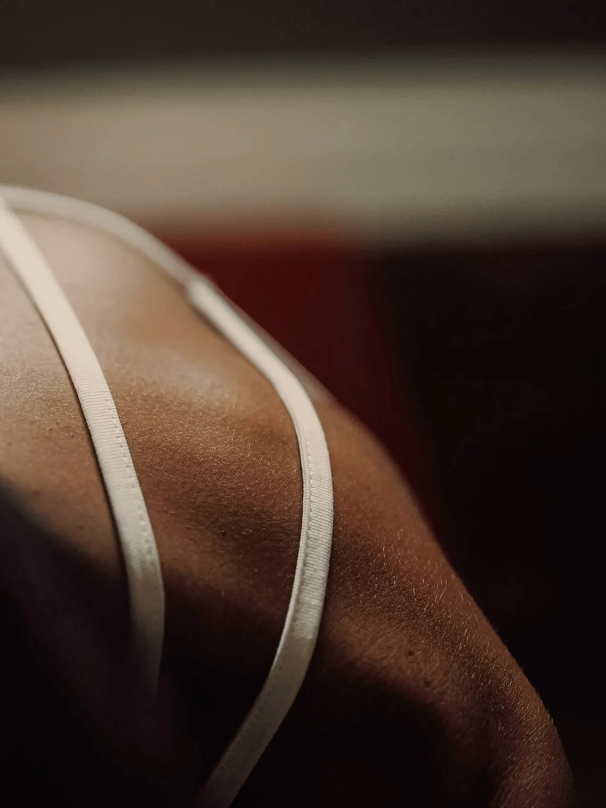 Close-up of tan satin fabric with white piping, focusing on the texture and lines.