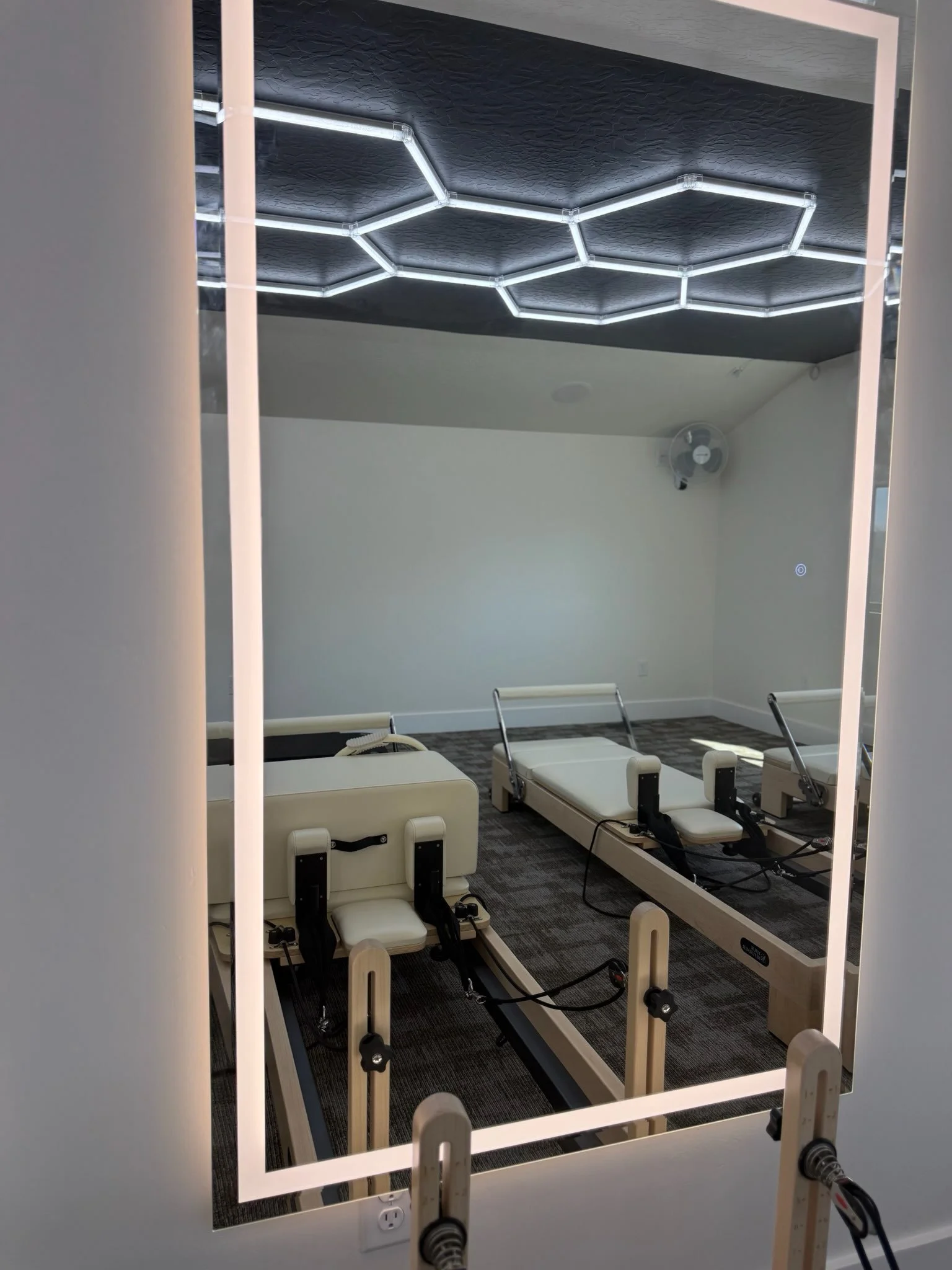 A room with robotic rehabilitation beds and a hexagon-shaped light fixture on the ceiling.