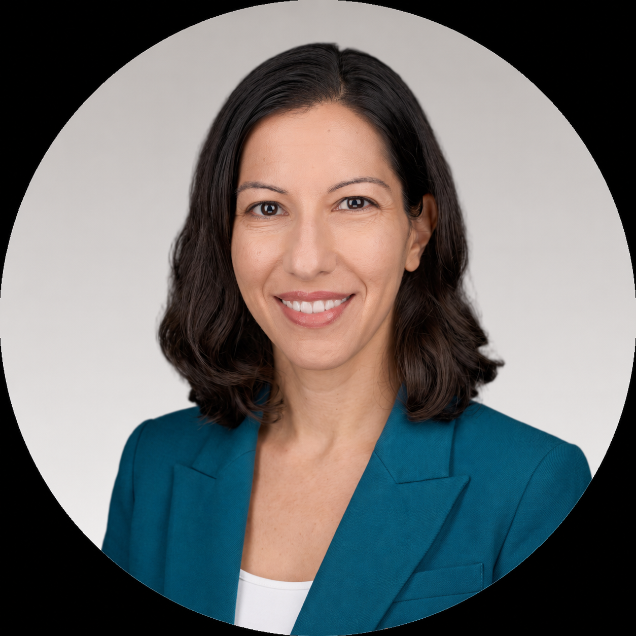 Professional headshot of a woman with shoulder-length dark hair, smiling, wearing a teal blazer and white top against a plain light background.