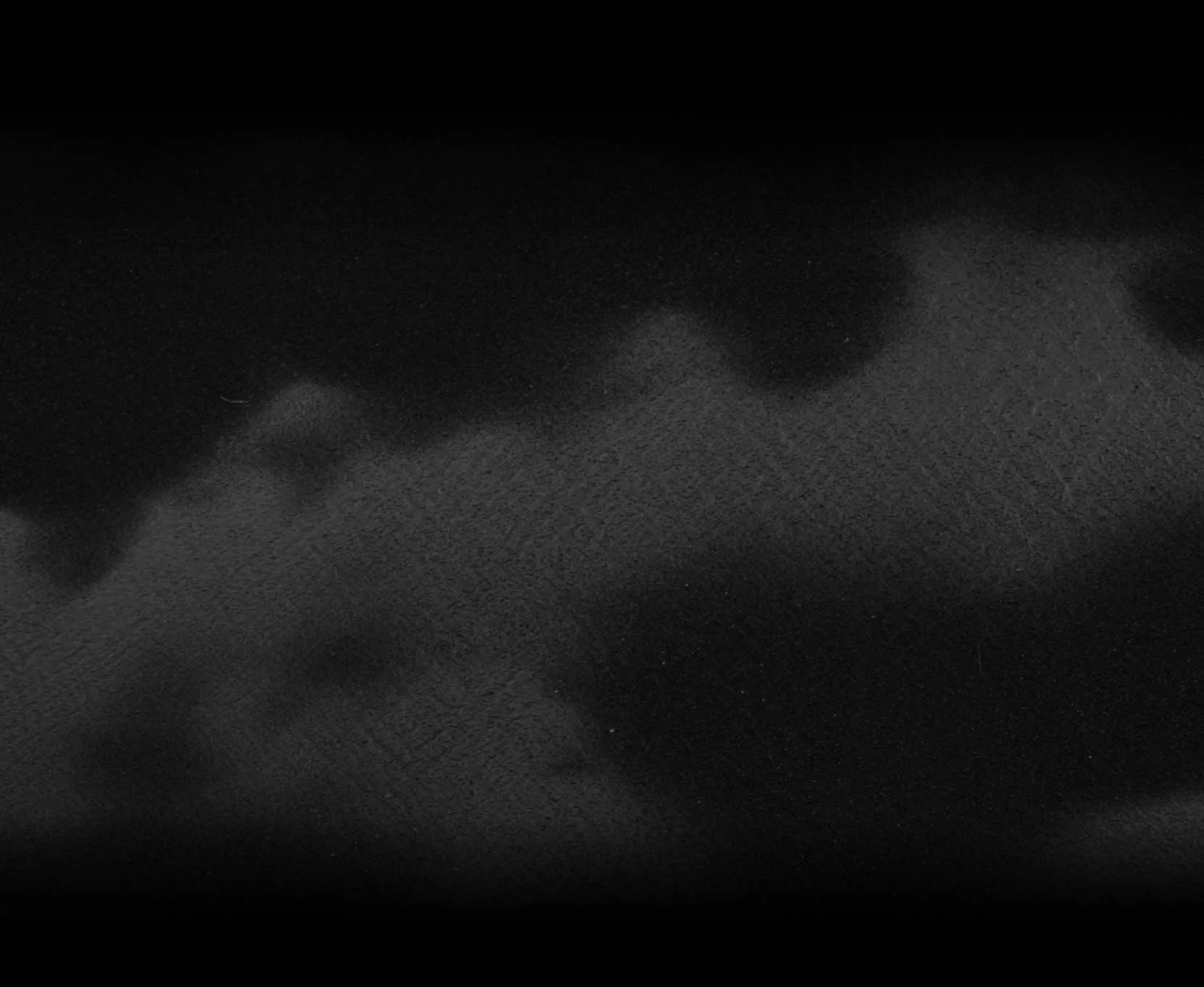 Close-up of a black, textured surface with a subtle pattern.