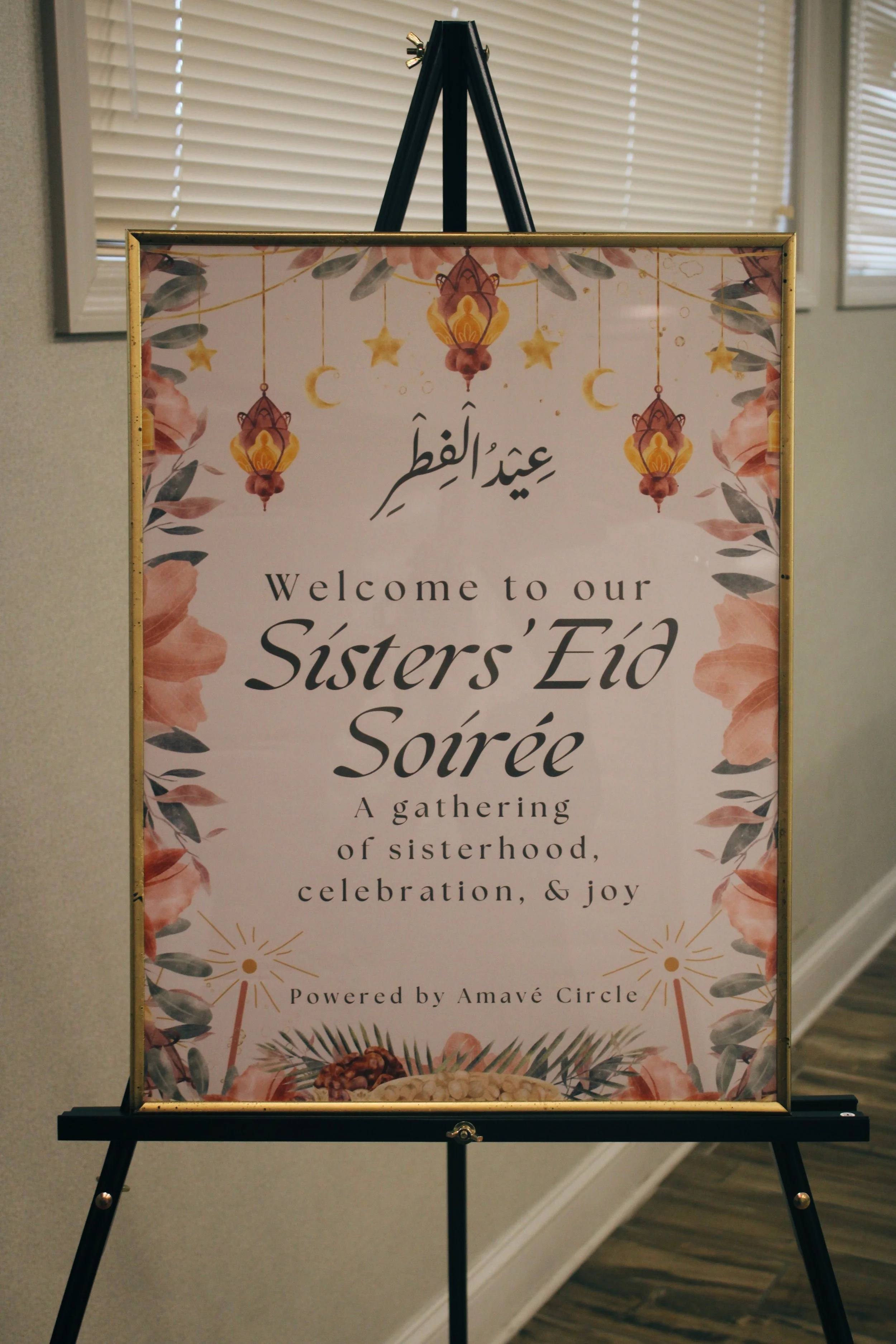 Sign welcoming guests to a Sister's Eid Soirée, with floral and lantern decorations at the top, and food illustrations at the bottom.