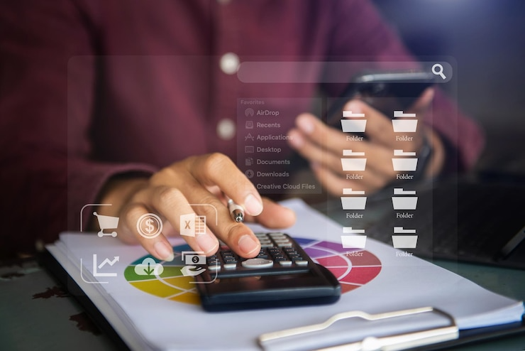 Person using calculator and smartphone with digital folder icons and financial graphics overlay.