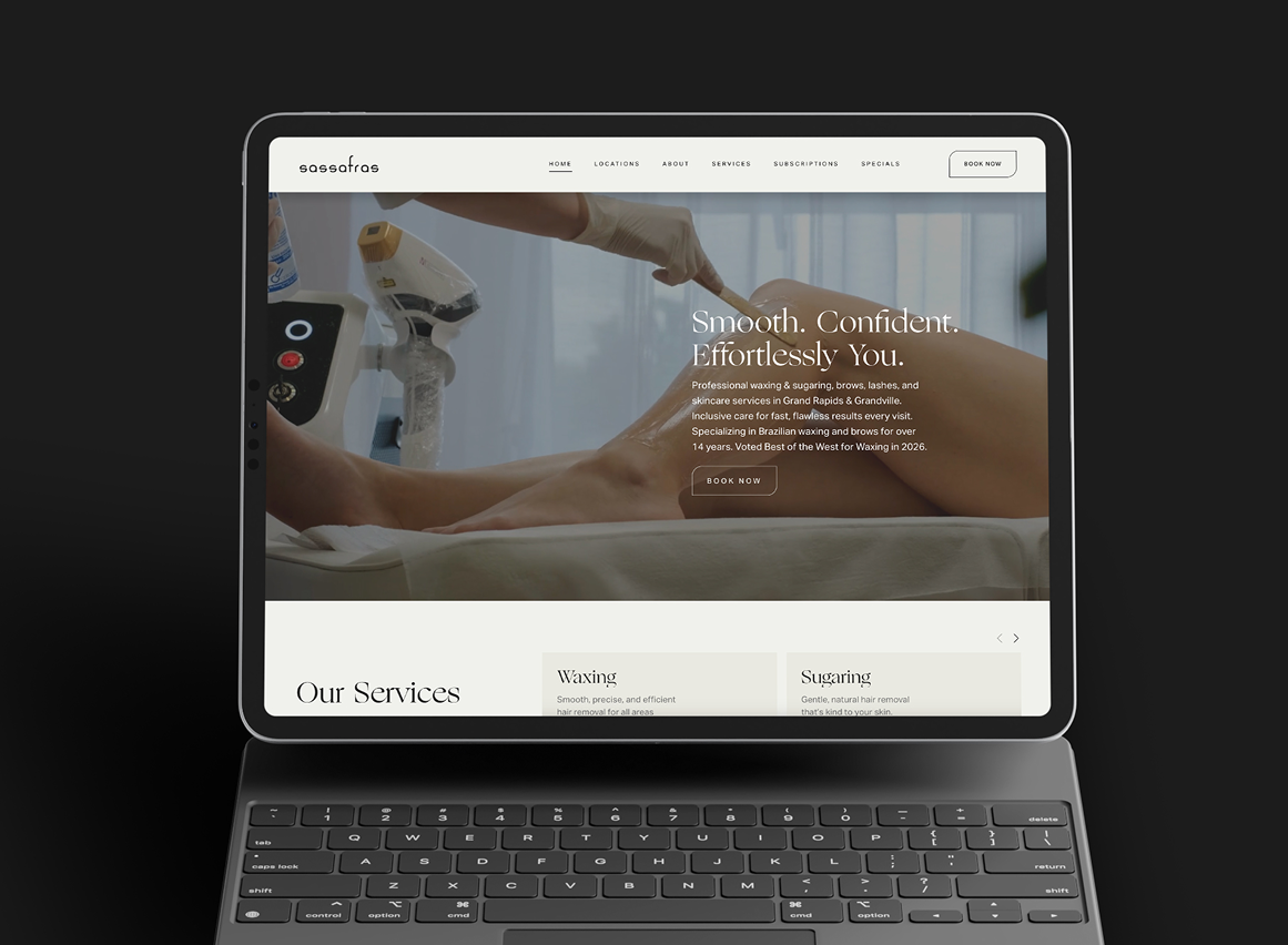 A tablet displaying a website for a waxing and skincare service, with an image of a person receiving a body waxing treatment for Sassafras Salons in Grand Rapids, Michigan.