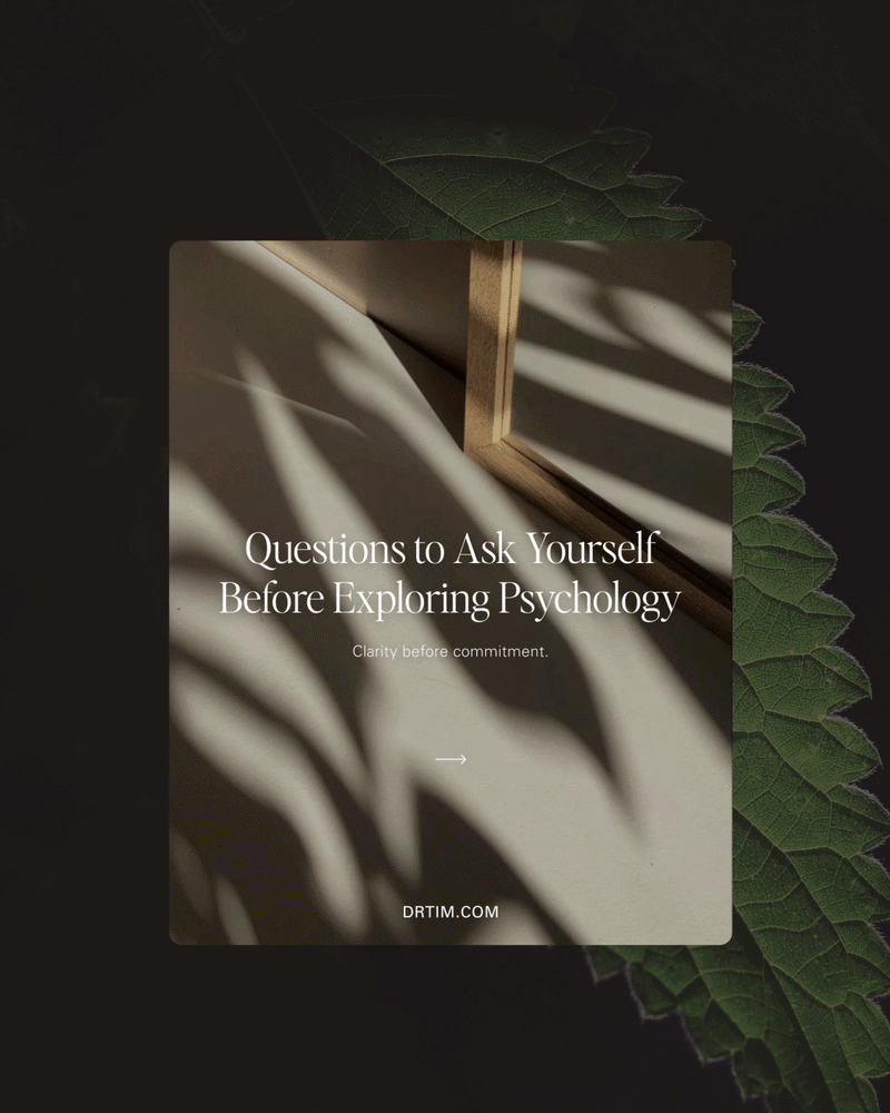 A book titled "Questions to Ask Yourself Before Exploring Psychology" with sunlight creating shadow patterns on the pages, set against a dark leafy background.