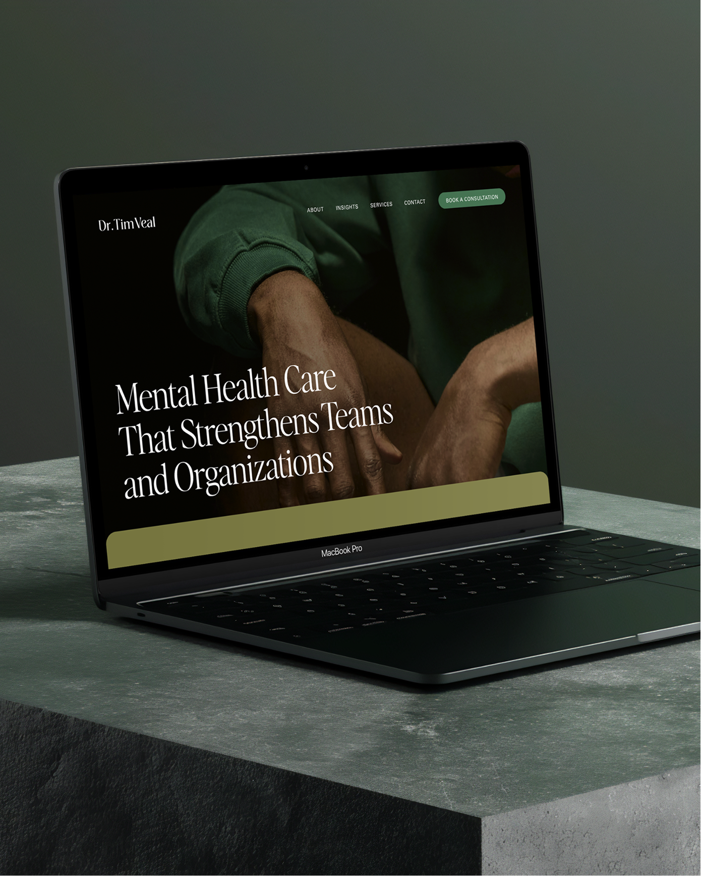 Laptop displaying a website for Dr. Tim Veal, focusing on mental health care and team strengthening services, with a green-themed website layout.