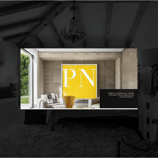 Indoor view of a modern room with a chandelier, a large window showing green trees outside, and a web page displayed on a screen featuring a yellow logo with the letters 'PN' for Philip Nimmo Design in California.