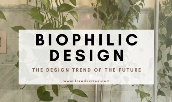 Sign with the text 'Biophilic Design' and 'The Design Trend of the Future' against a background of green plants.